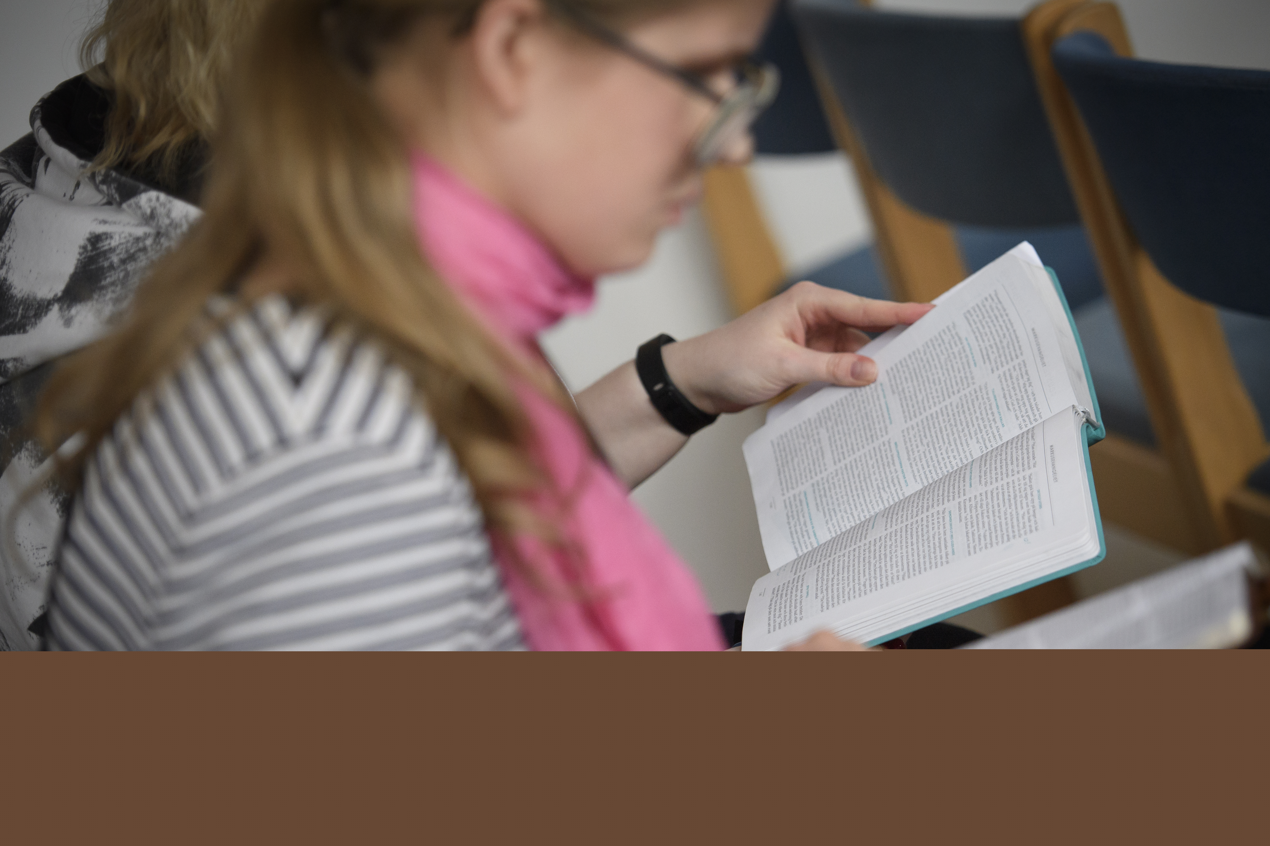 Två personer sitter bredvid varandra och läser varsin bibel.