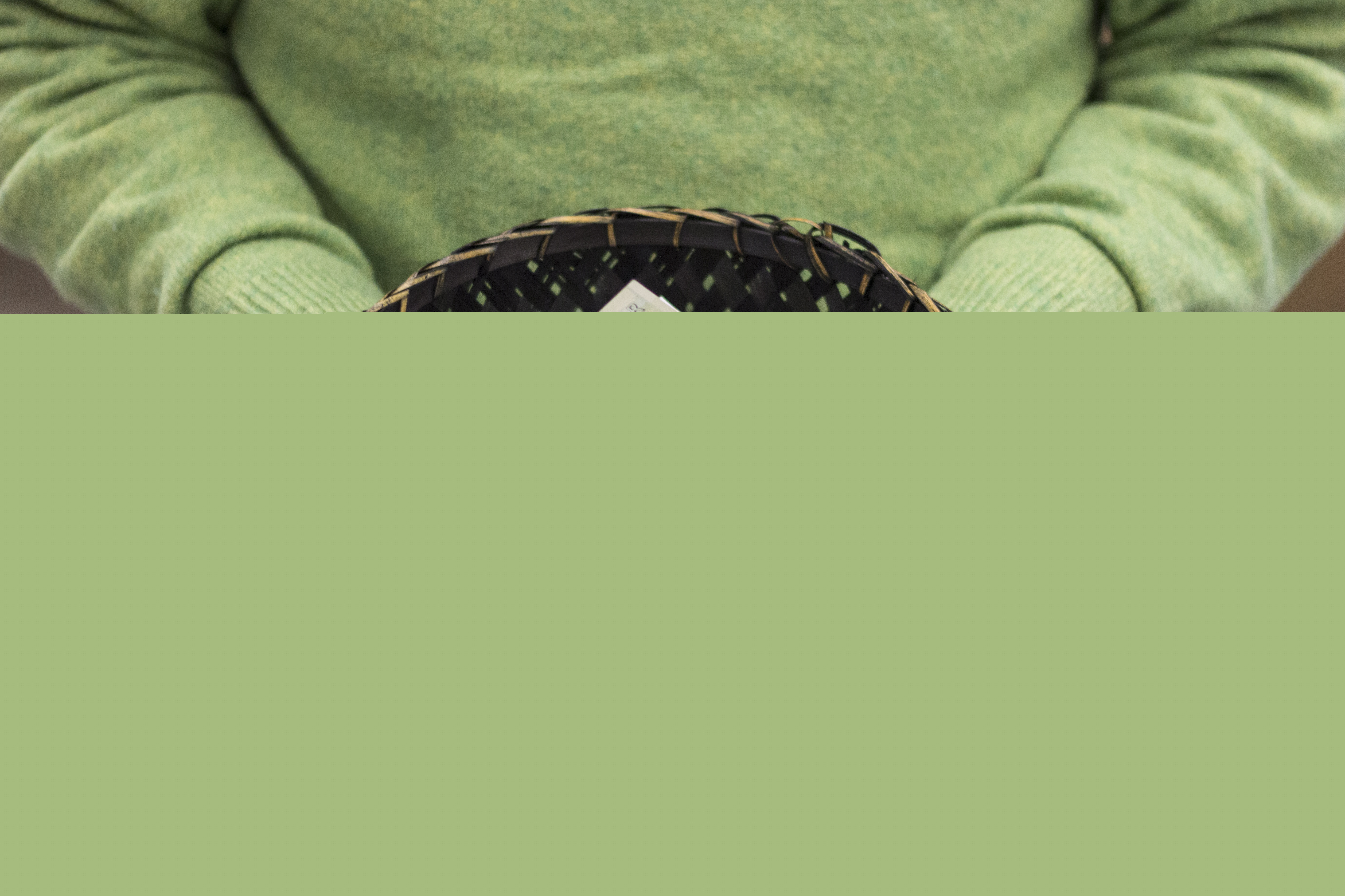 Någon håller en korg fylld med sedlar.