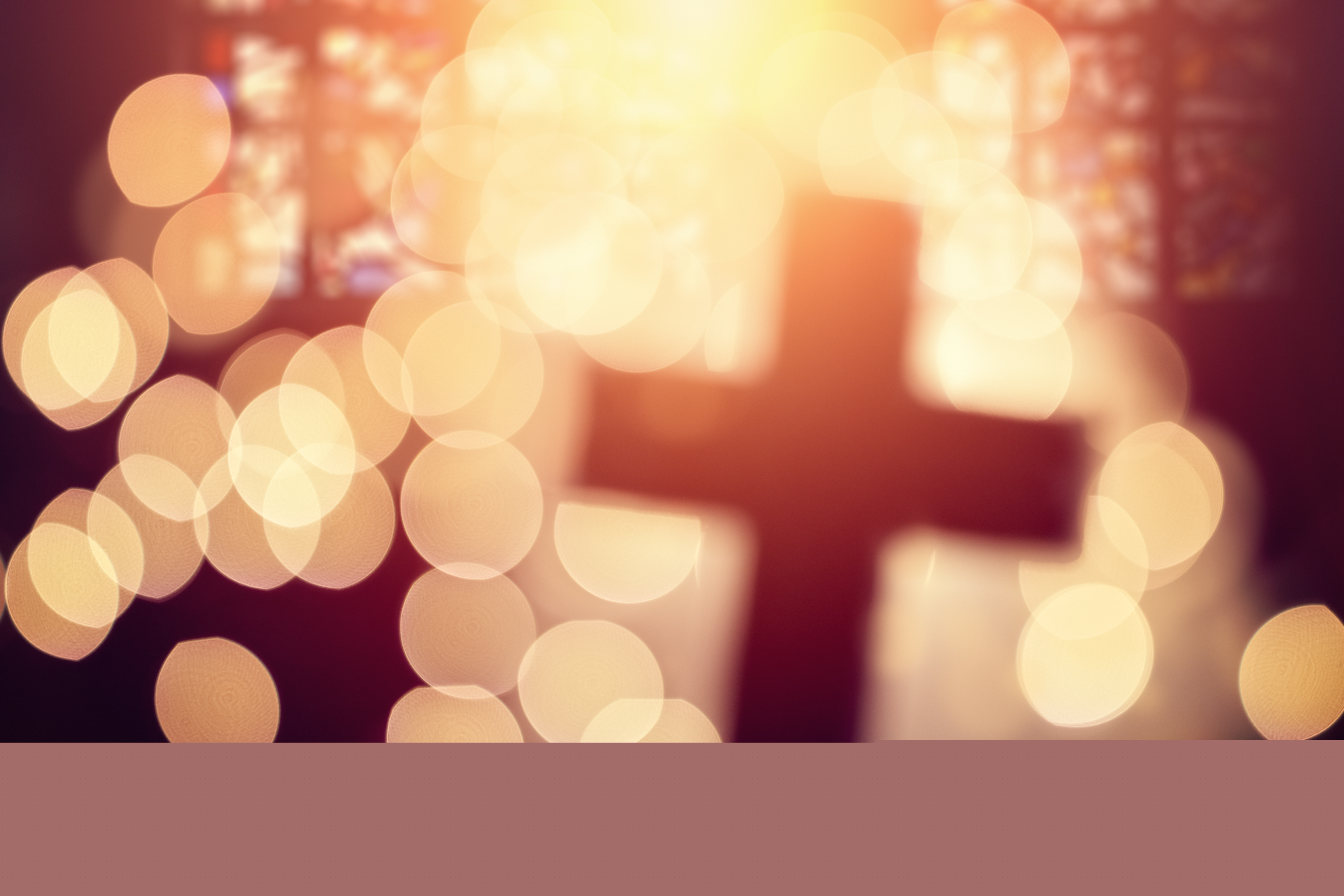 En oskarp bild av ett kors i motljus.