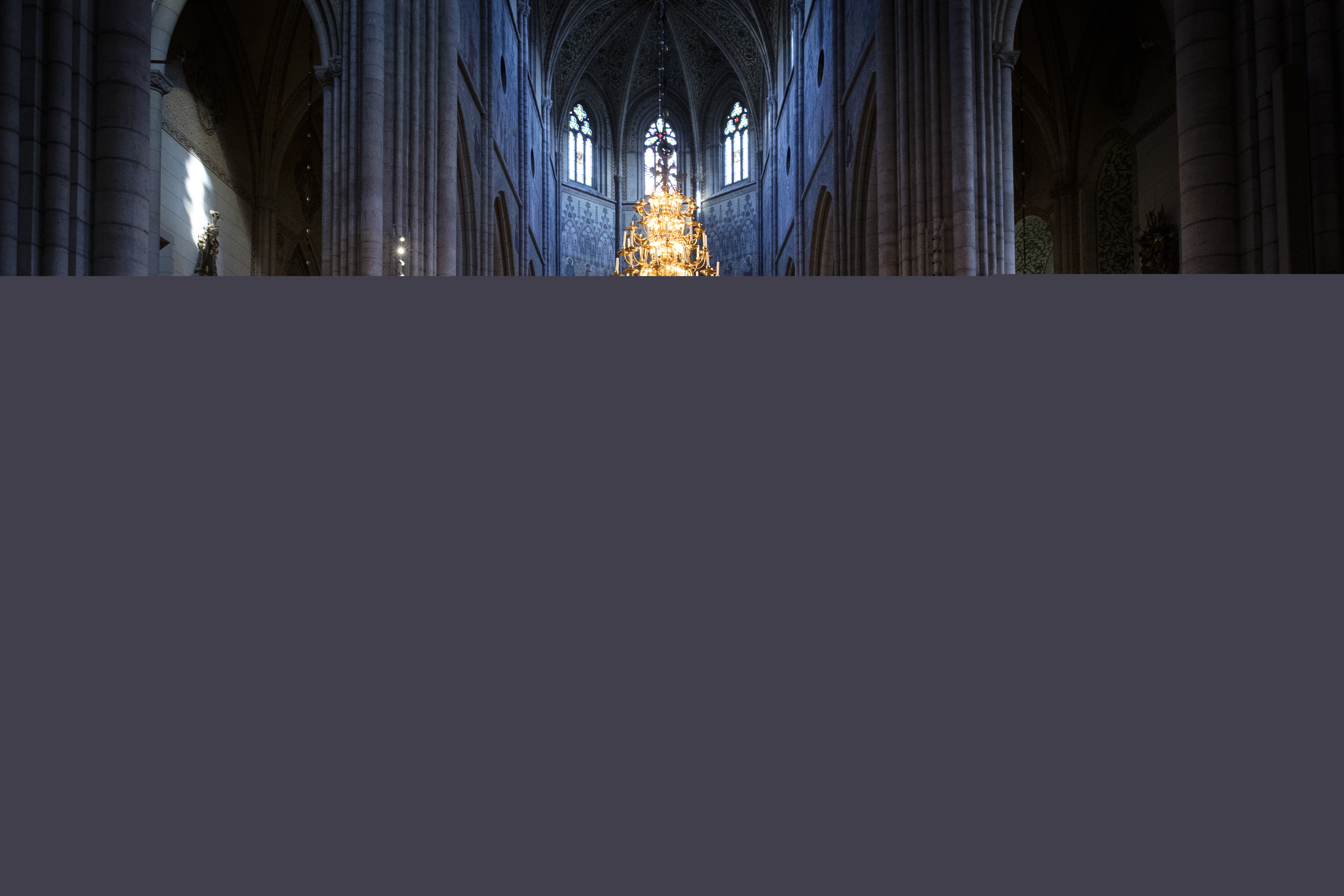 Uppsala domkyrkas gosskör i rödgula och blåa kåpor sjunger i en fullsatt domkyrka.