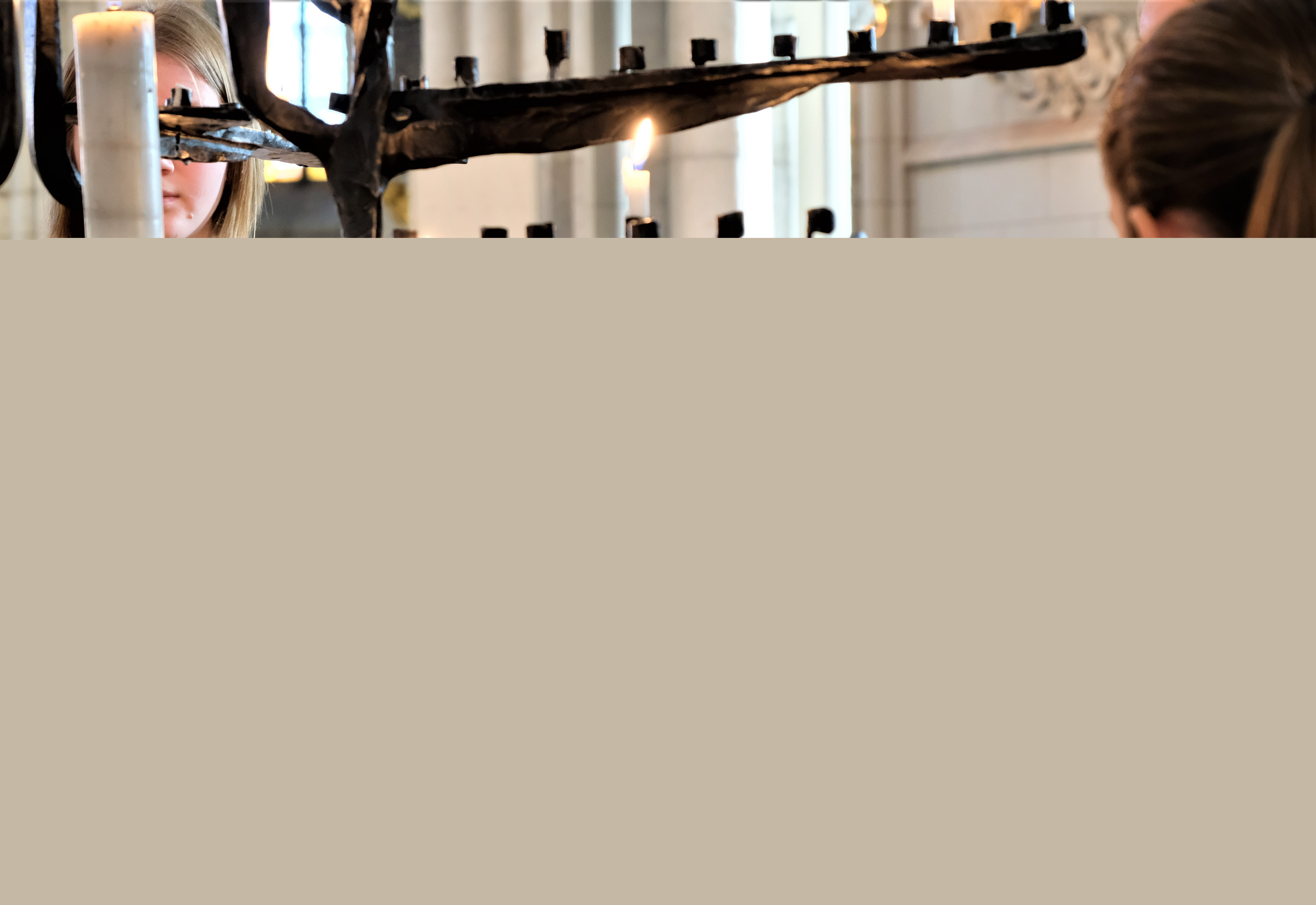 Flickor i svarta kåpor tänder ljus i Uppsala domkyrka.