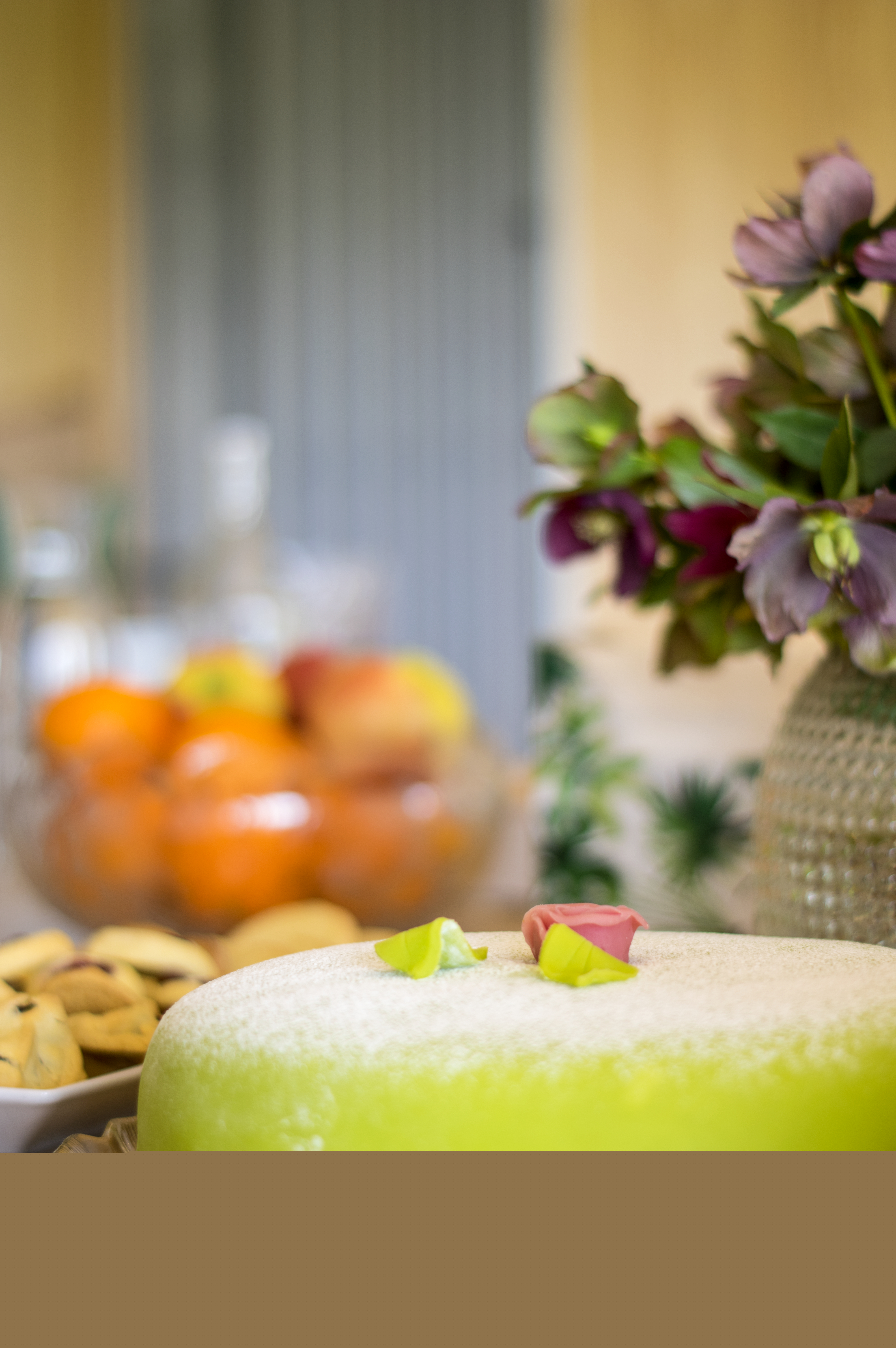 En ljusgrön prinsesstårta med en rosa ros på toppen står framdukad.