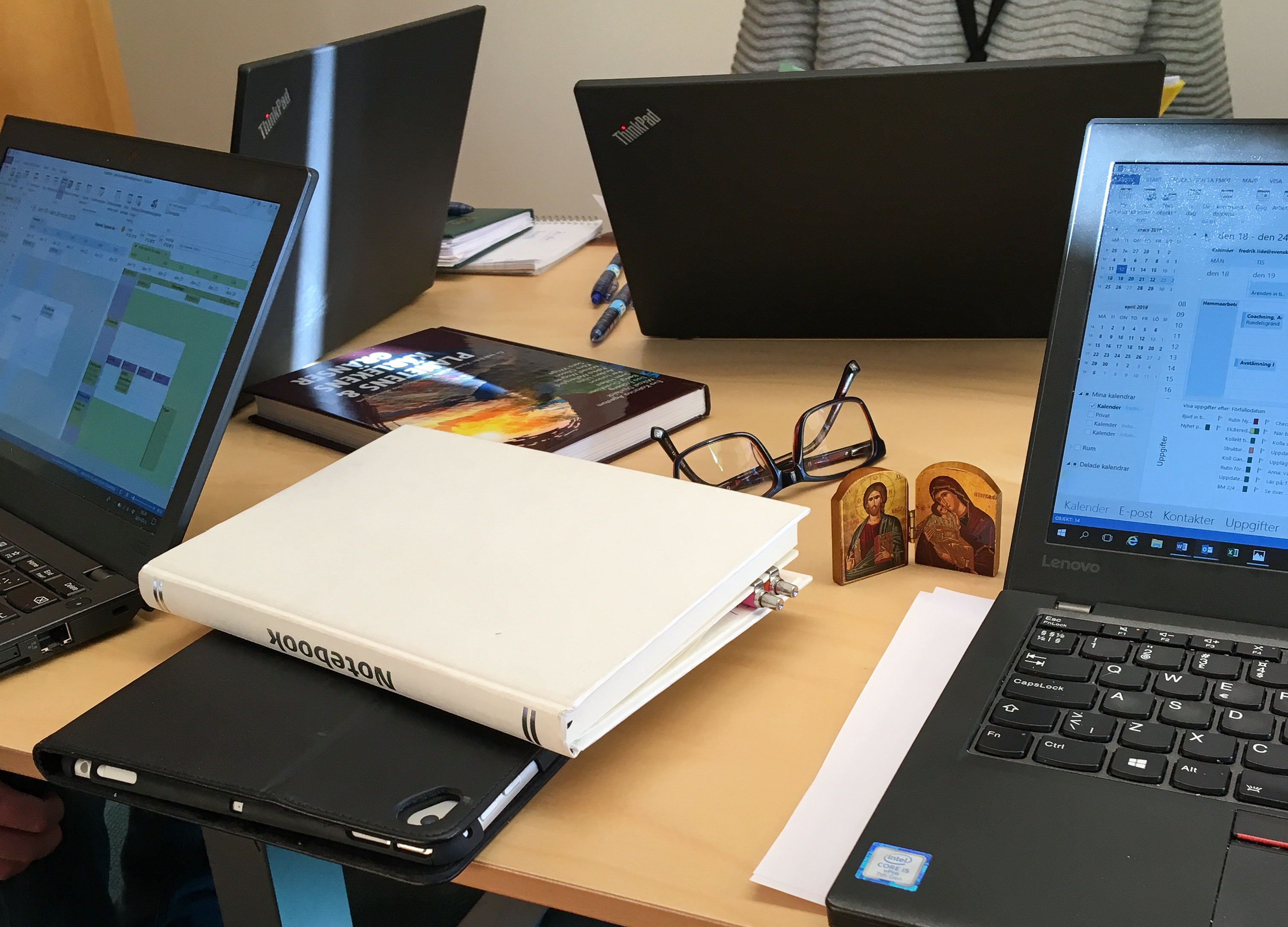 Fyra bärbara datorer står uppställda runt ett bord.