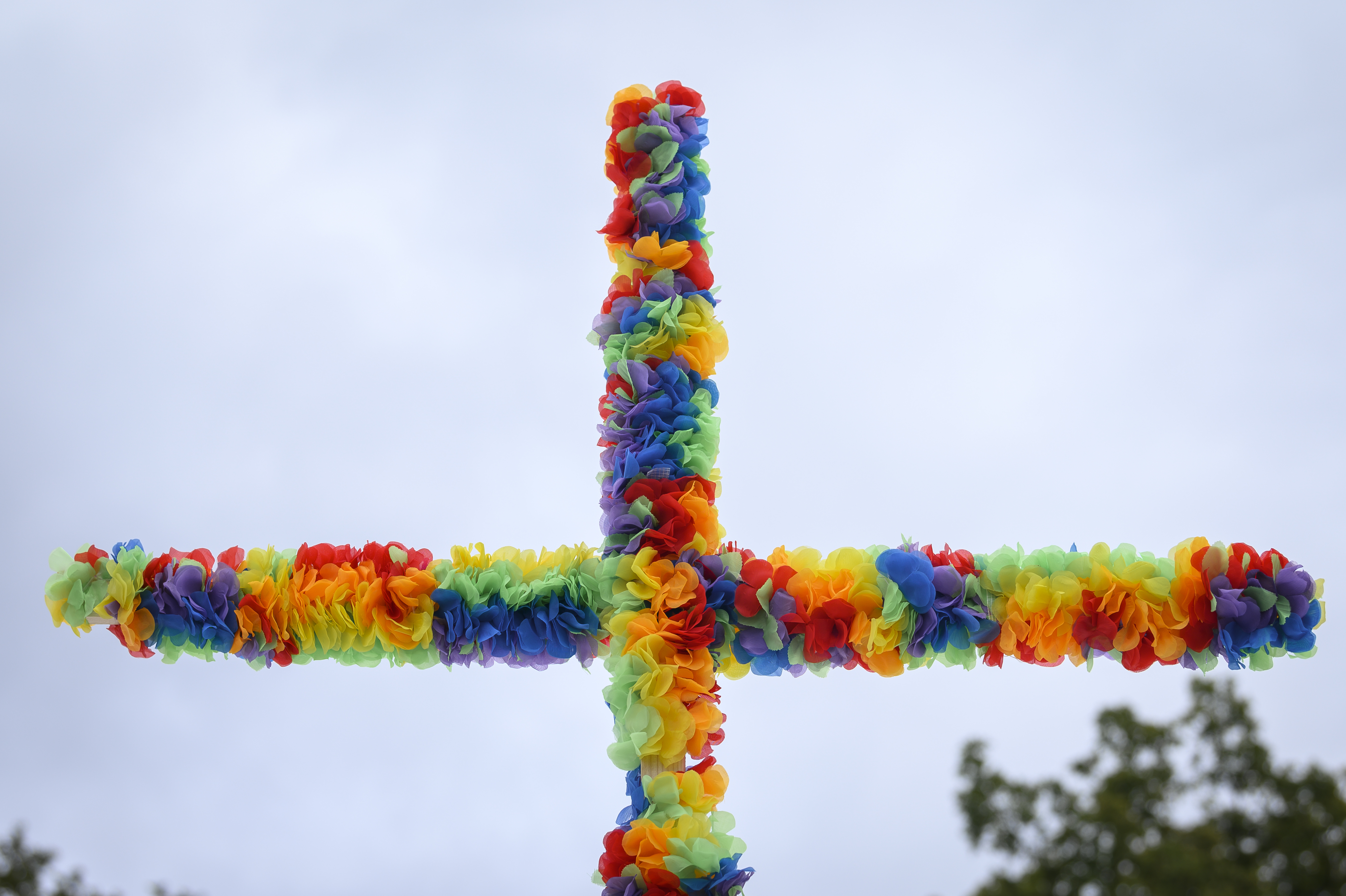 Ett kors av regnbågsfärgade blommor.