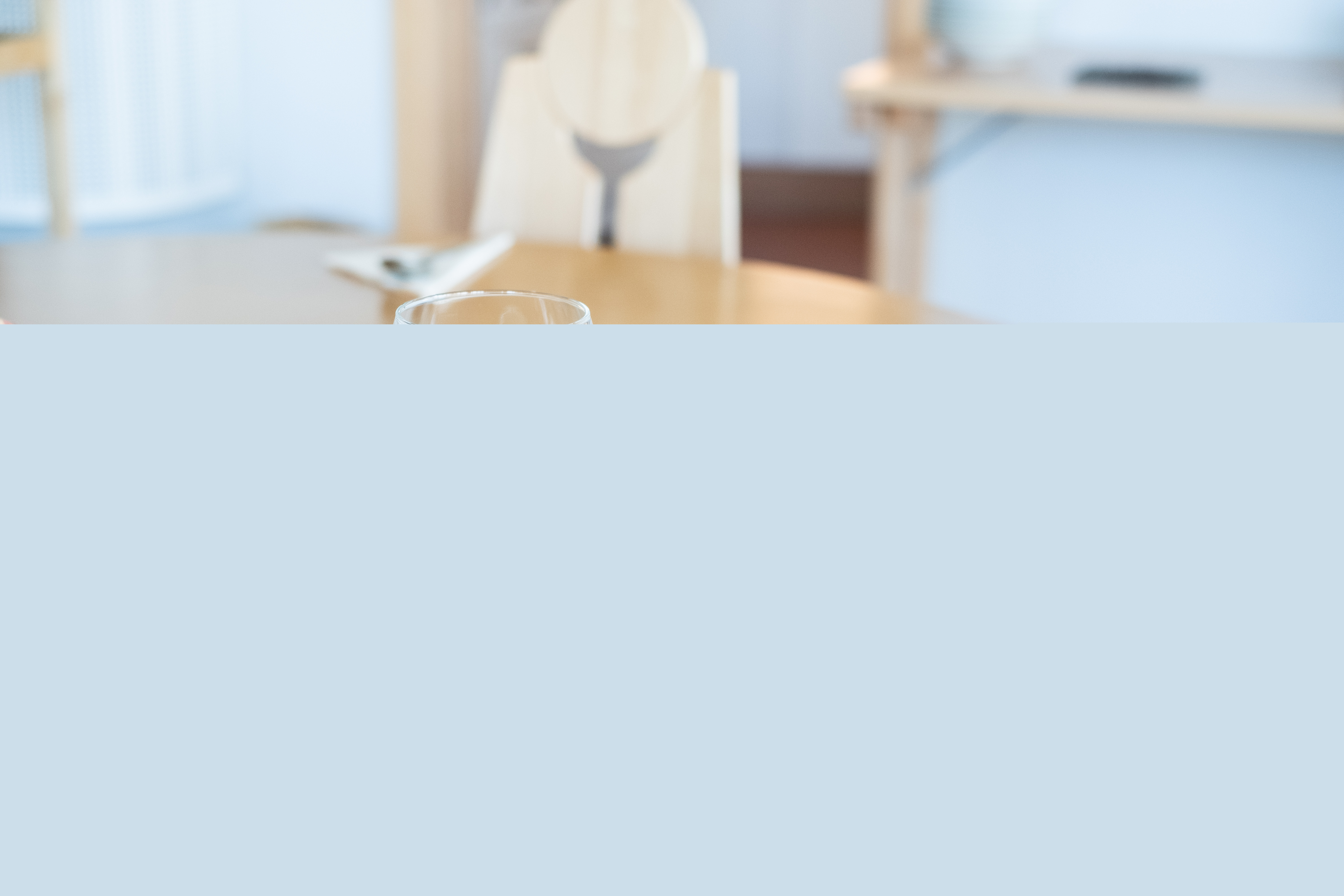 En skål soppa och en brödbit står framdukat på ett bord.