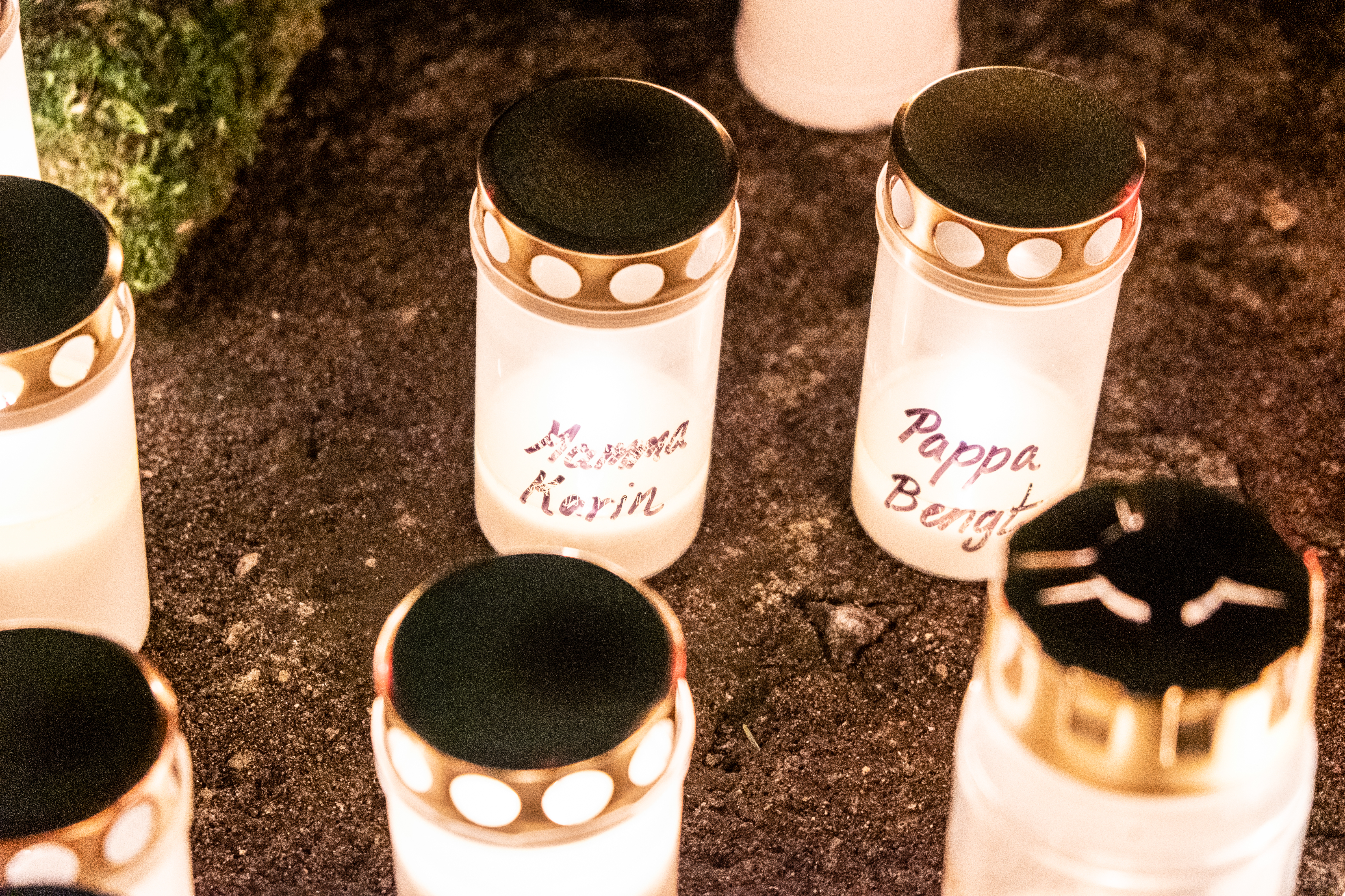 På ett par tända gravljus har någon skrivit Mamma Karin och Pappa Bengt.