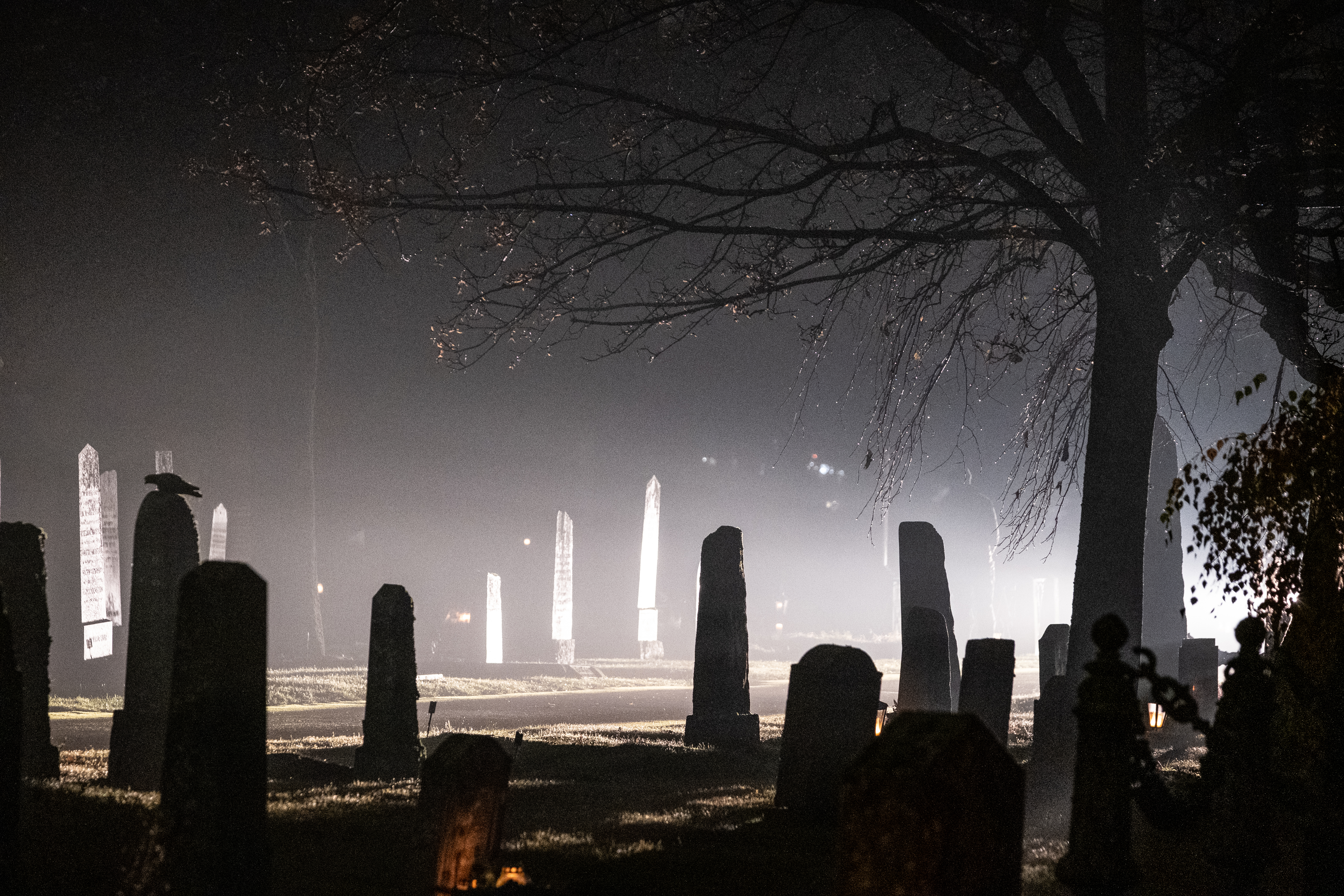 En mörk kyrkogård som lyses upp av en strålkastare.