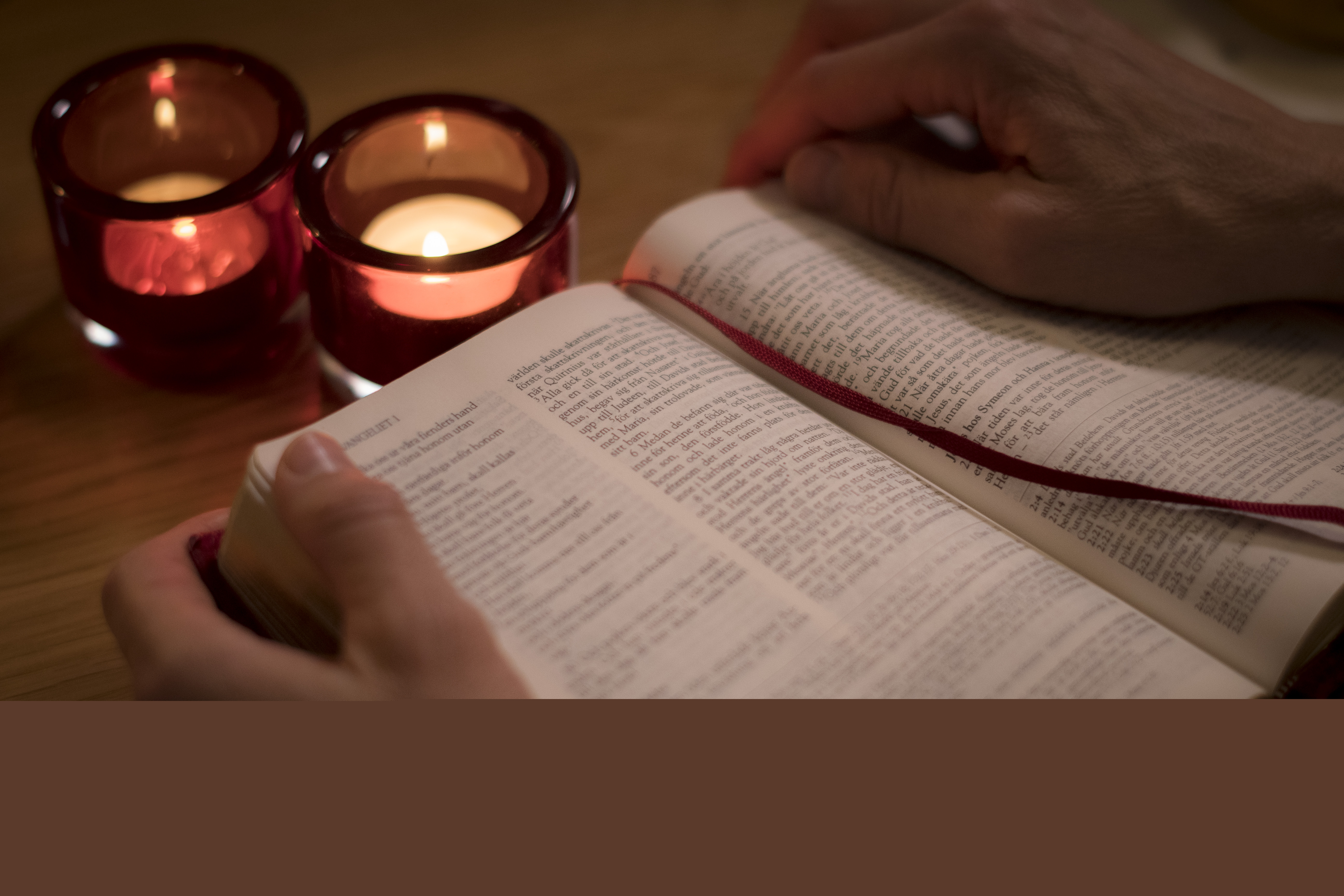 Någon har tänt ljus och läser bibeln.