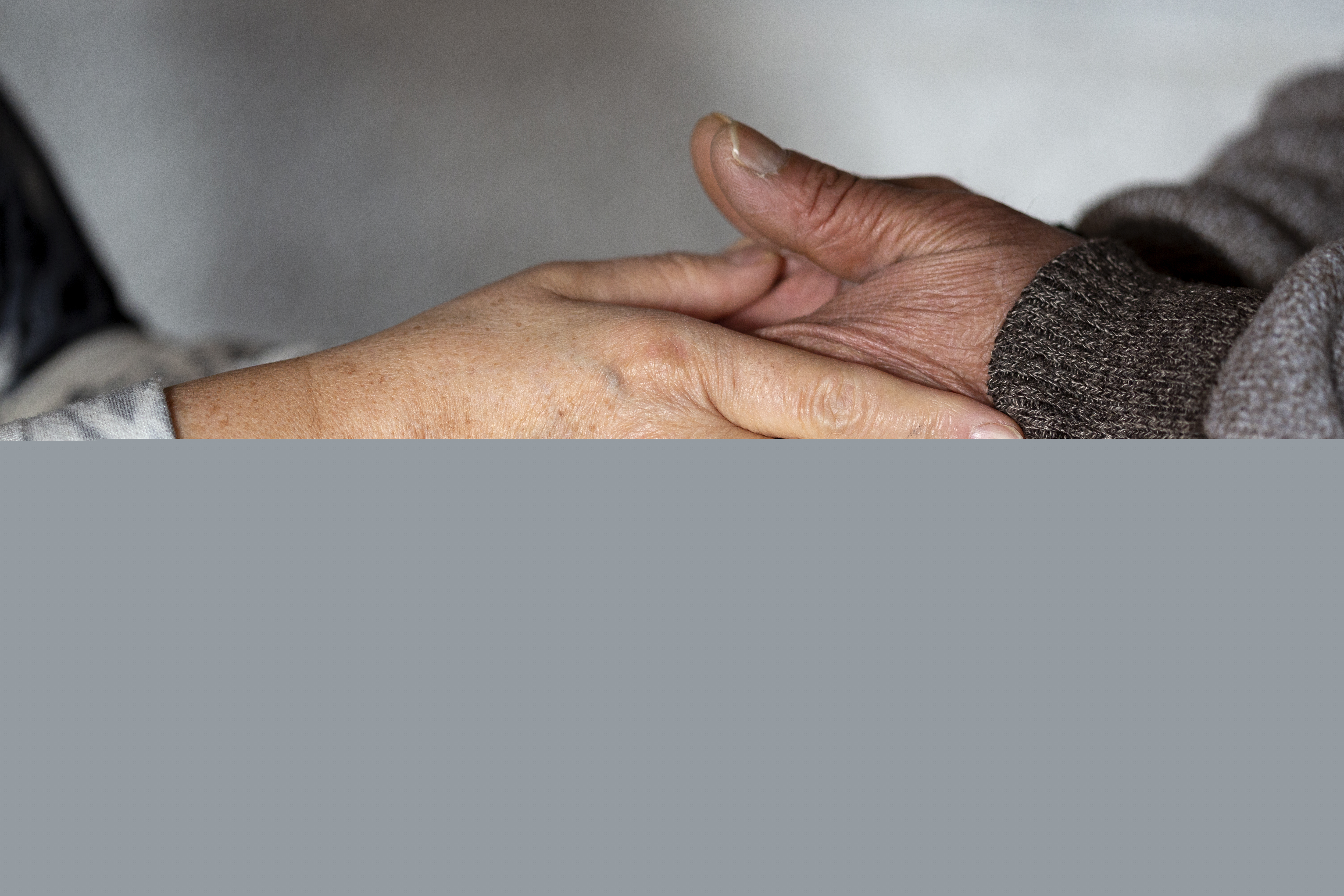 Två personer håller om varandras händer.