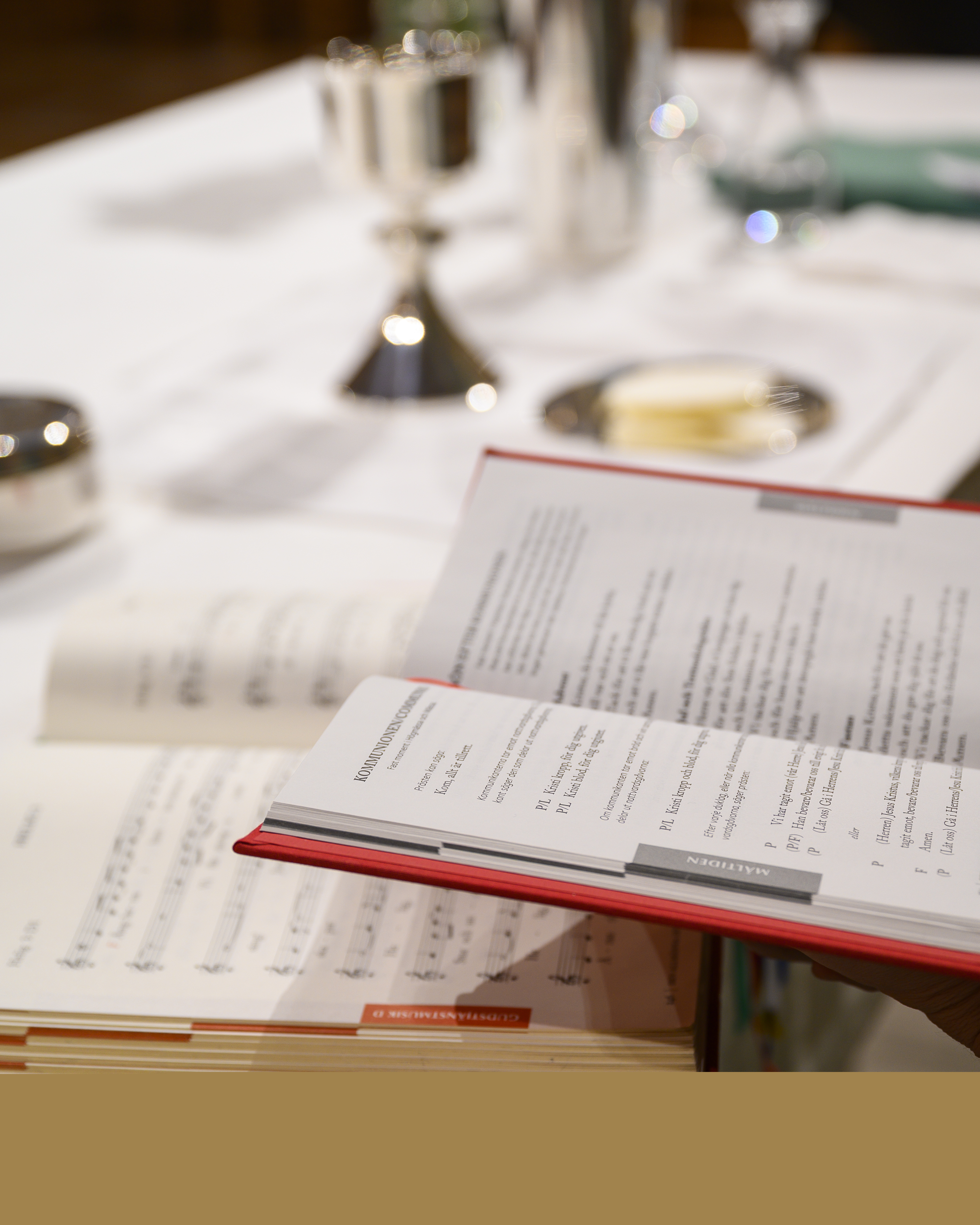 En psalmbok och en bönbok ligger uppslagna på nattvardsbordet.
