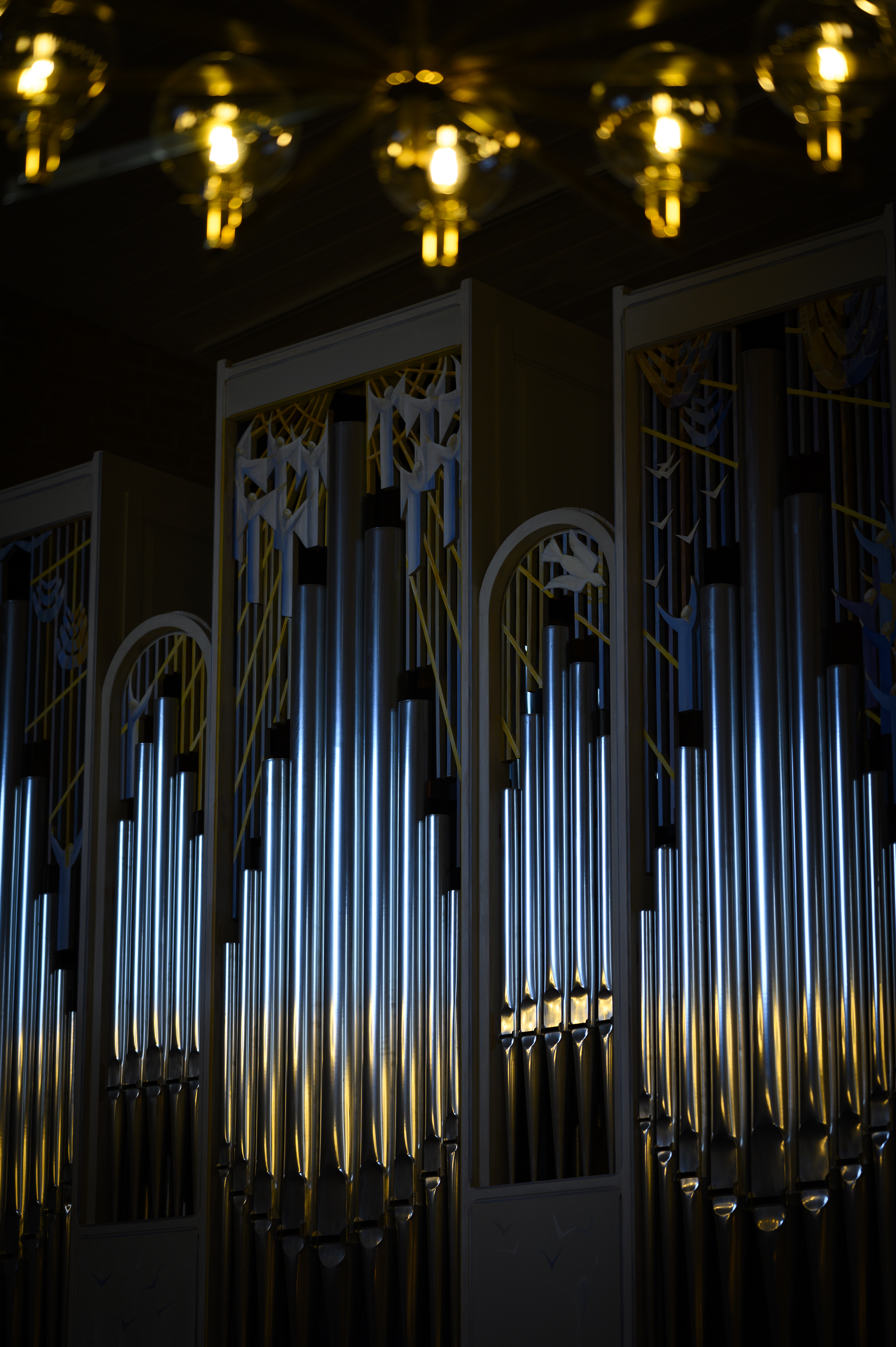 Solljus reflekteras i en kyrkorgels pipor.