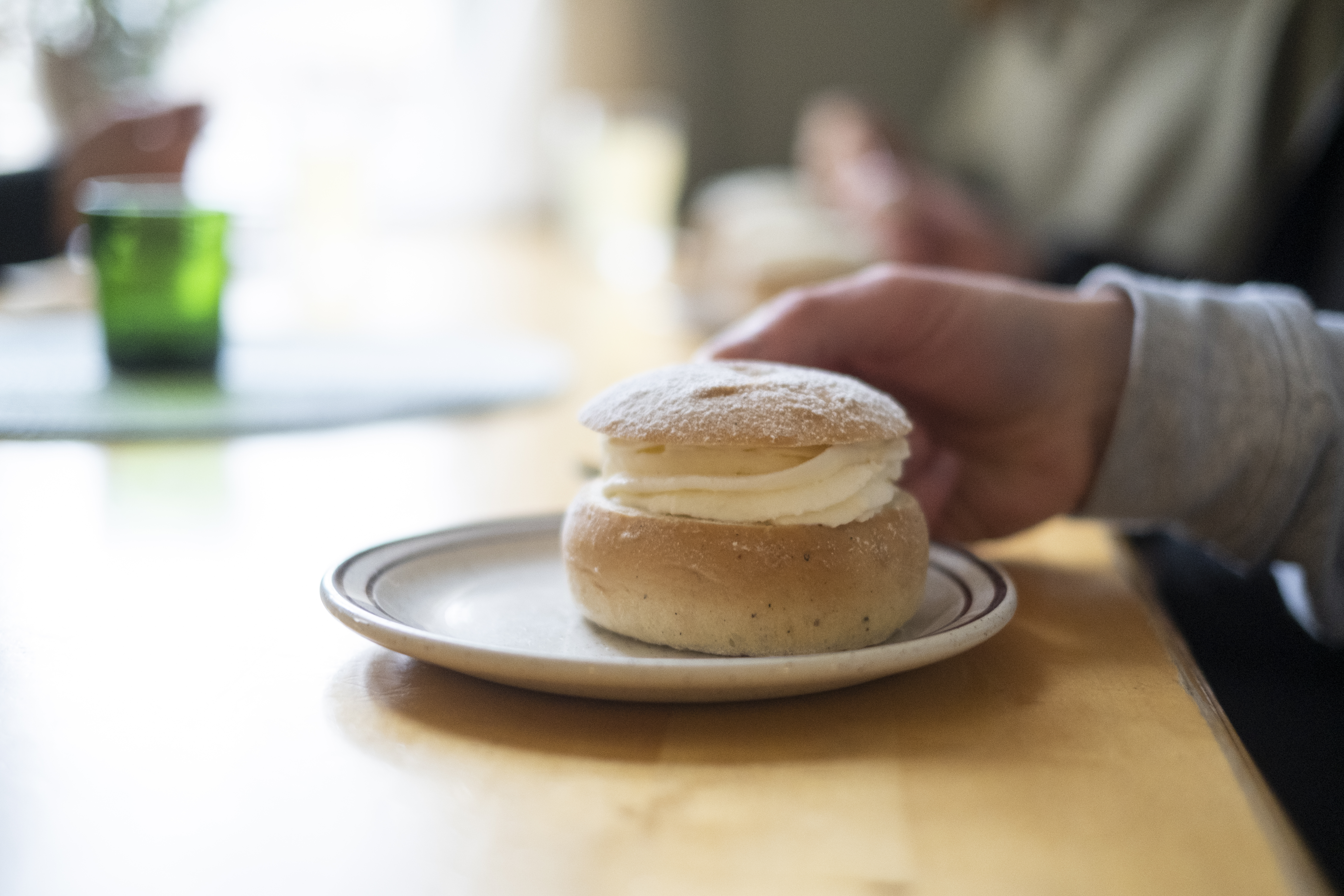 Någon sitter med en semla framför sig.
