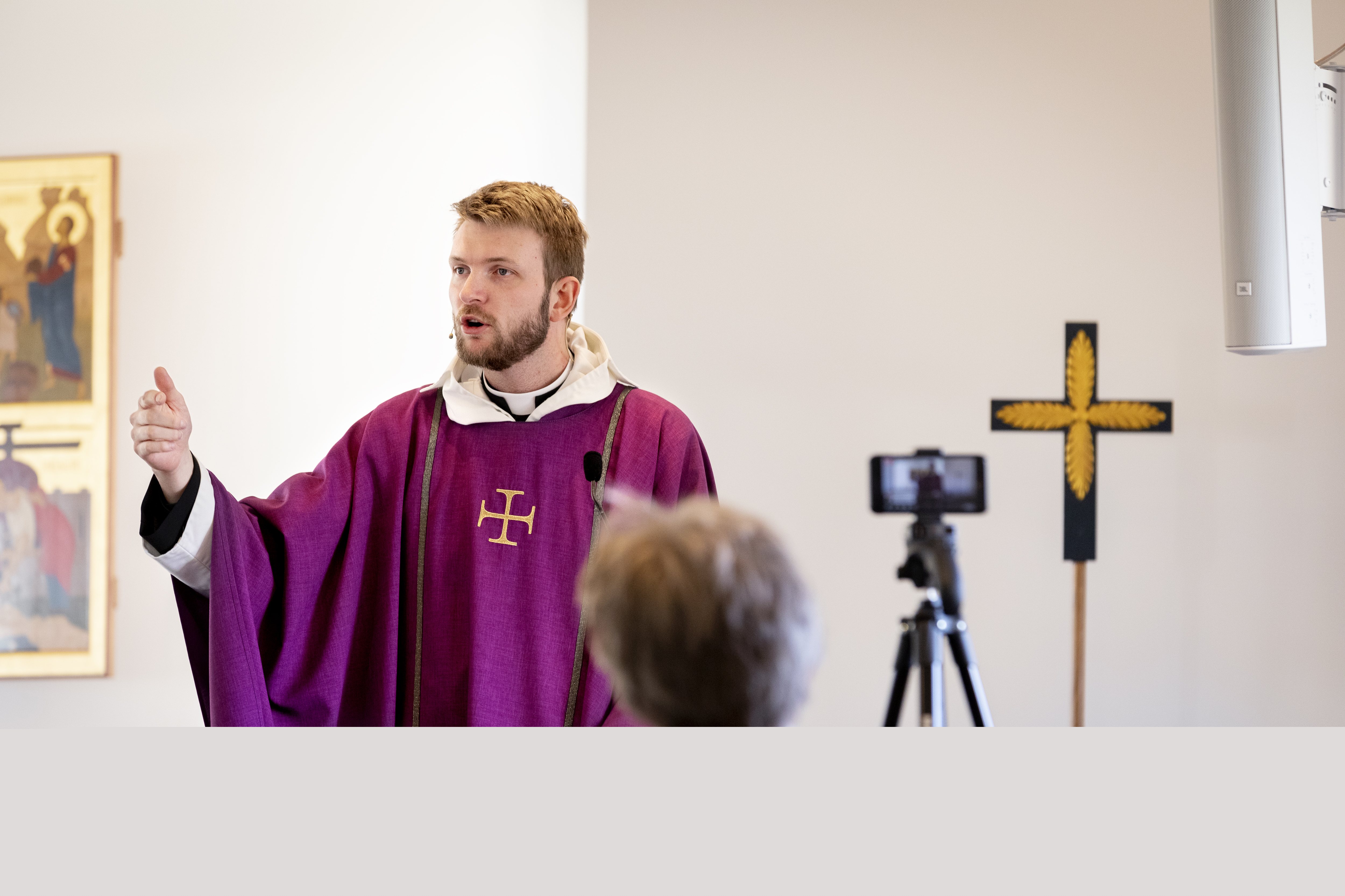En präst predikar framför en kamera som filmar för direktsändning på webben.