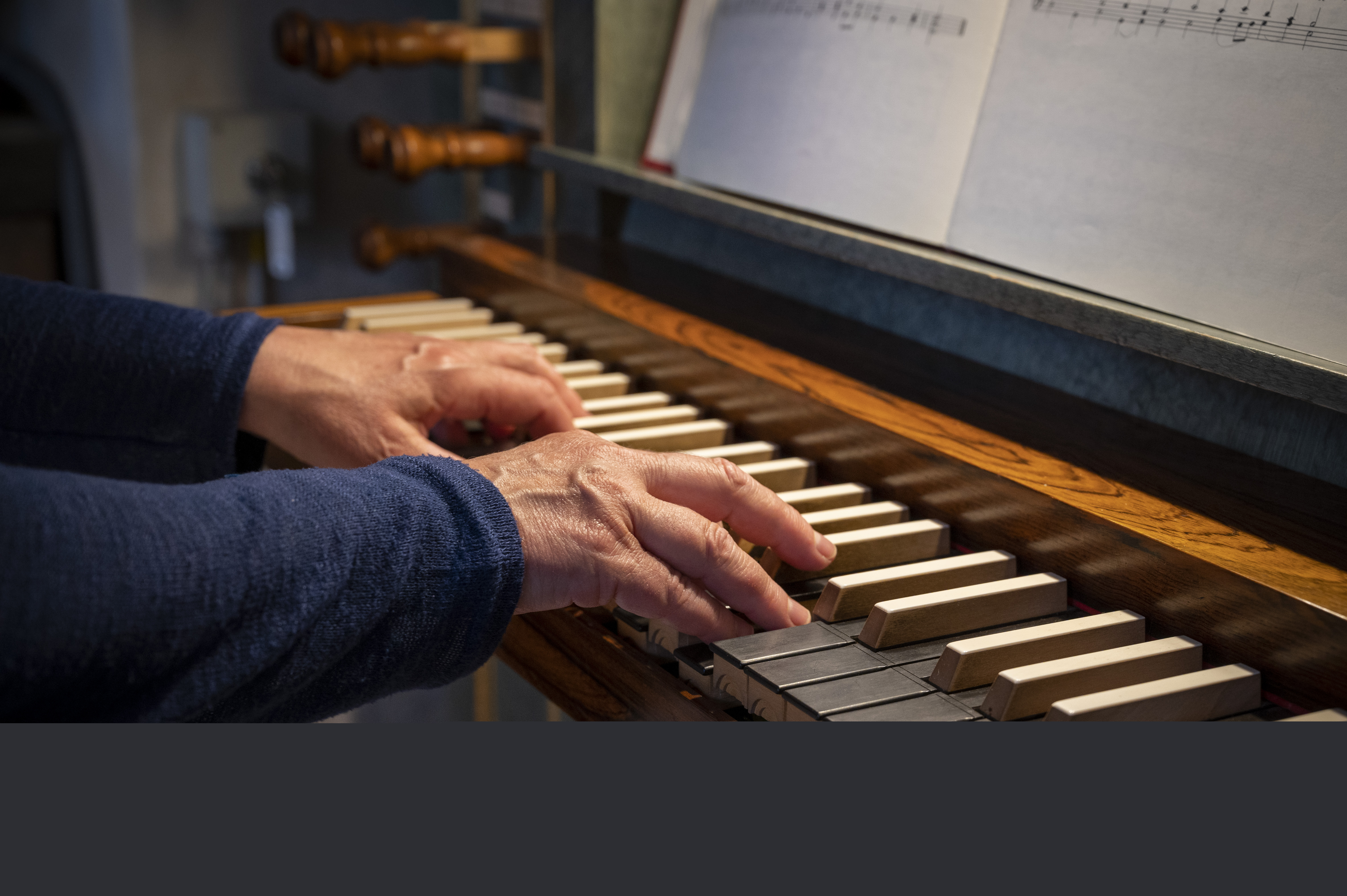 Ett par händer spelar på en kyrkorgel.