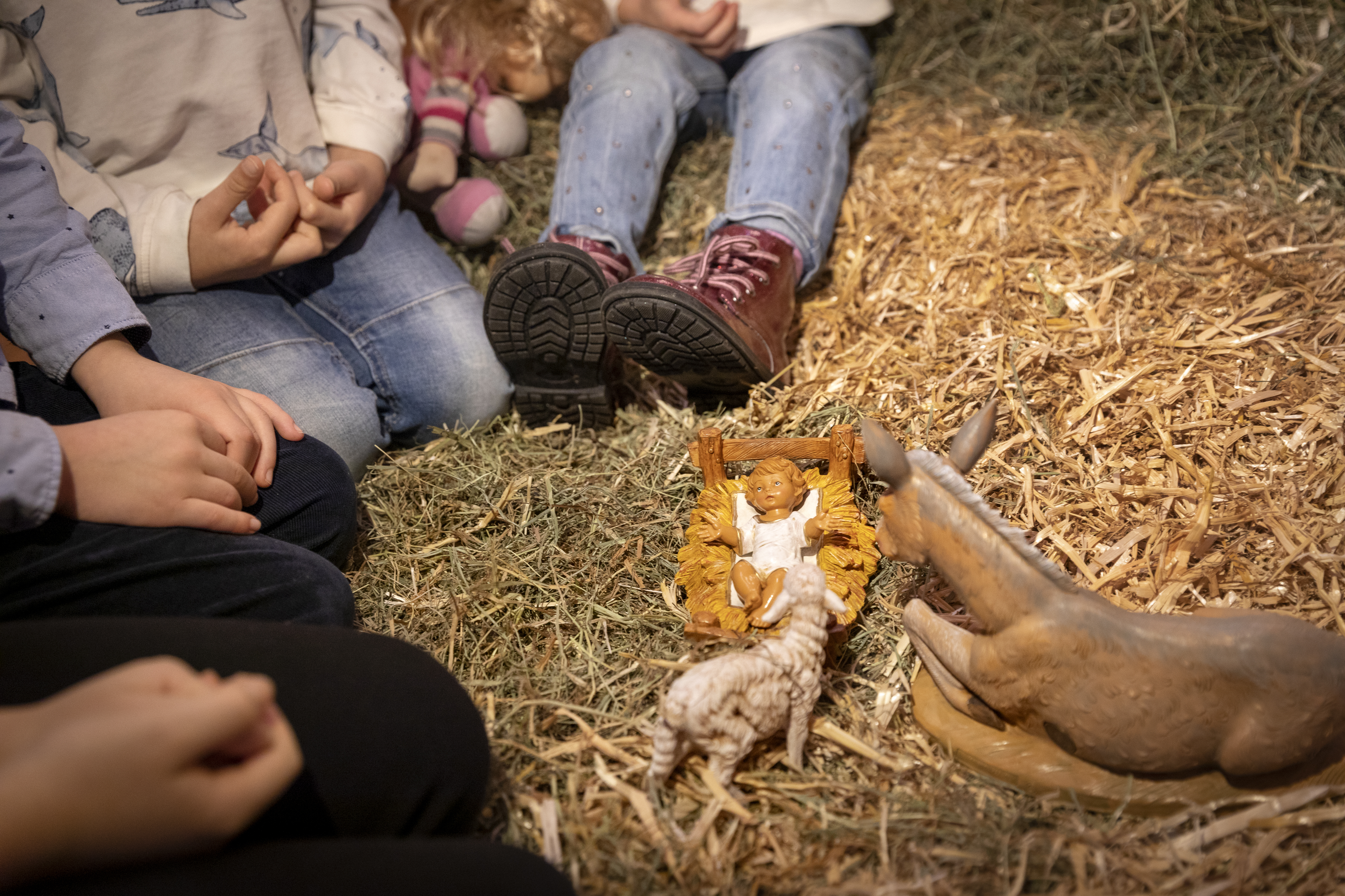 Några barn leker med dockorna i julkrubban.