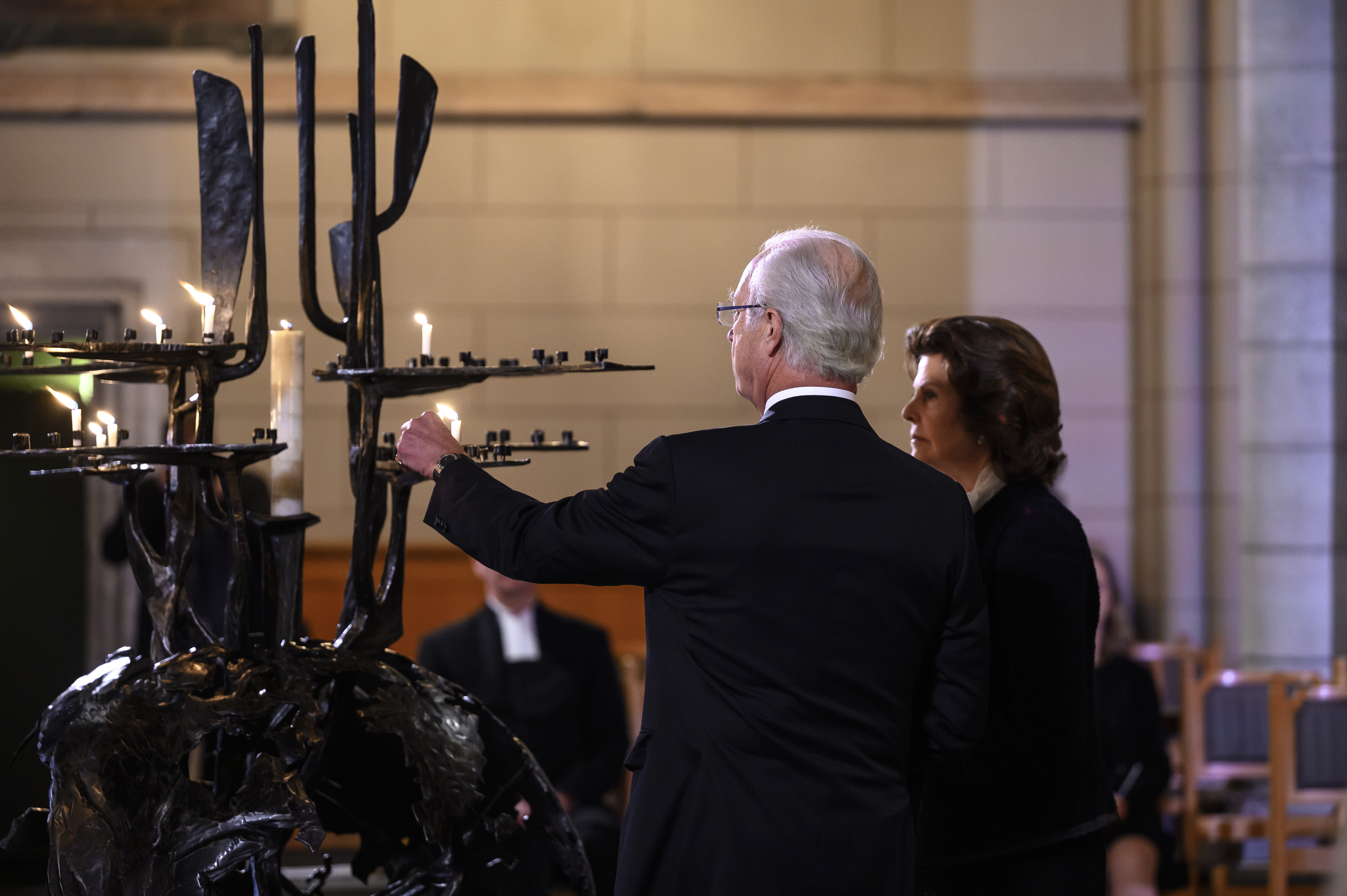 Kung Carl XVI Gustav och drottning Silvia tänder ljus i Uppsala domkyrka.