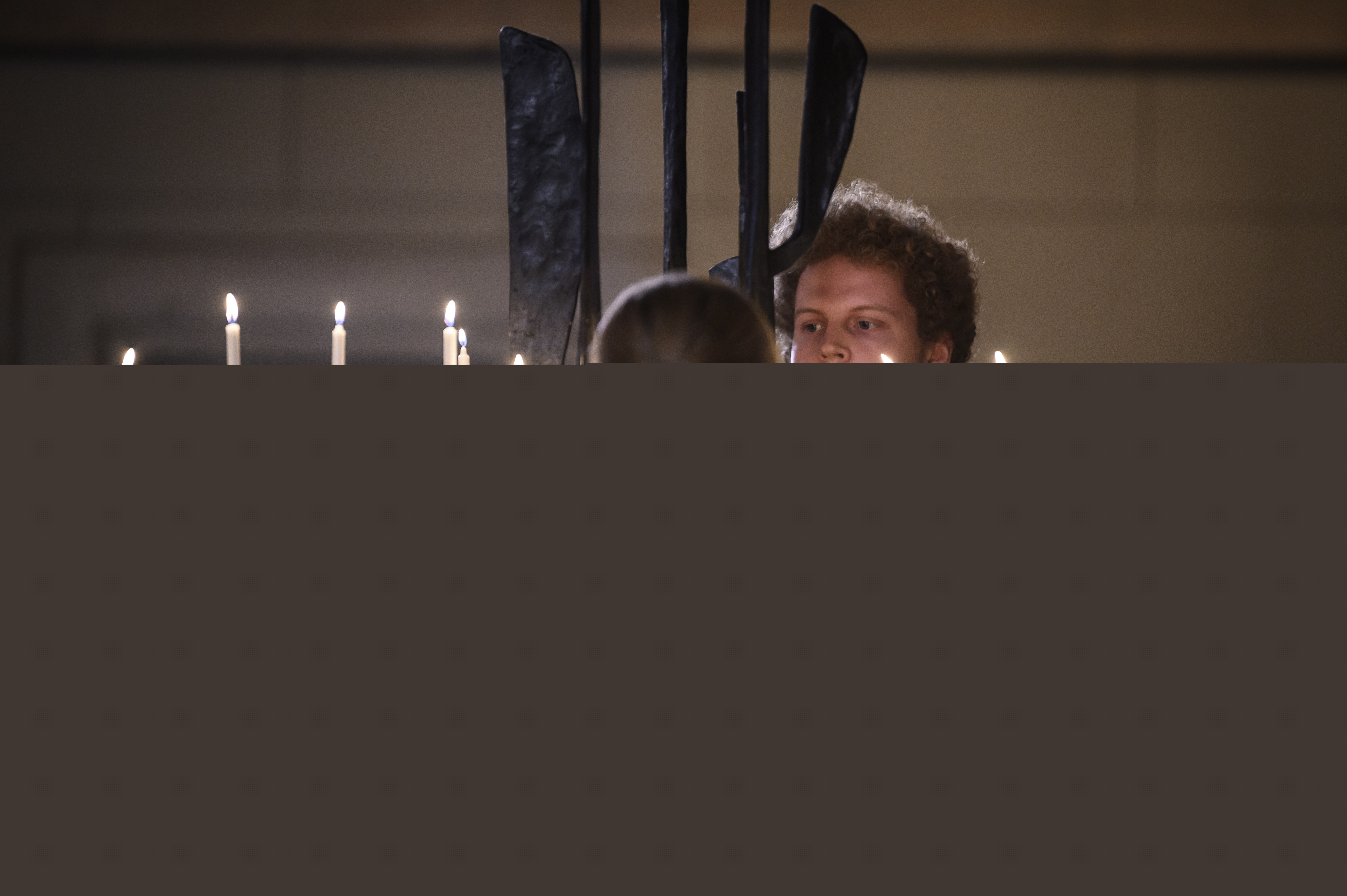 Två personer tänder ljus i Uppsala domkyrka.