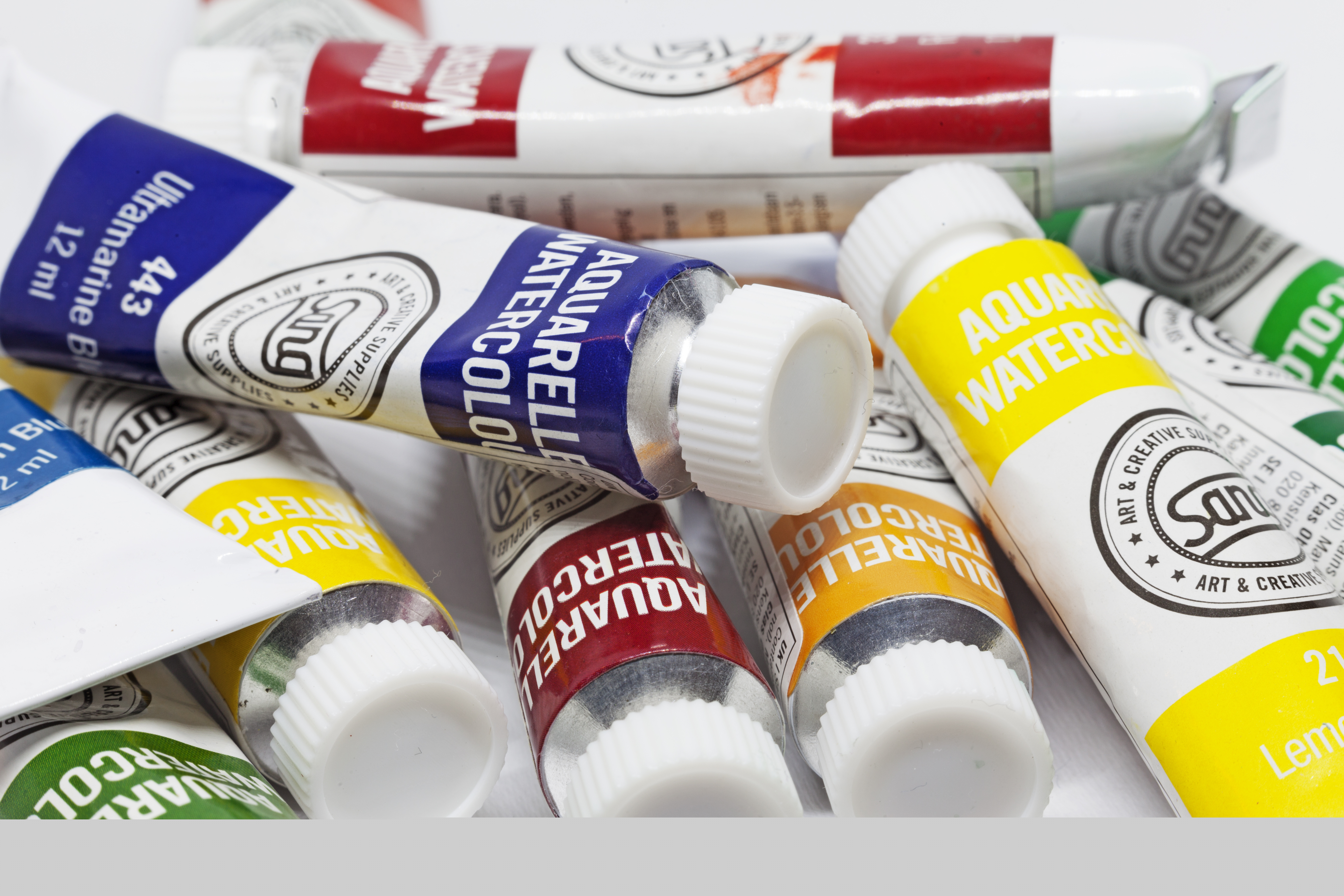 Närbild på en hög tuber med akvarellfärg i olika nyanser.