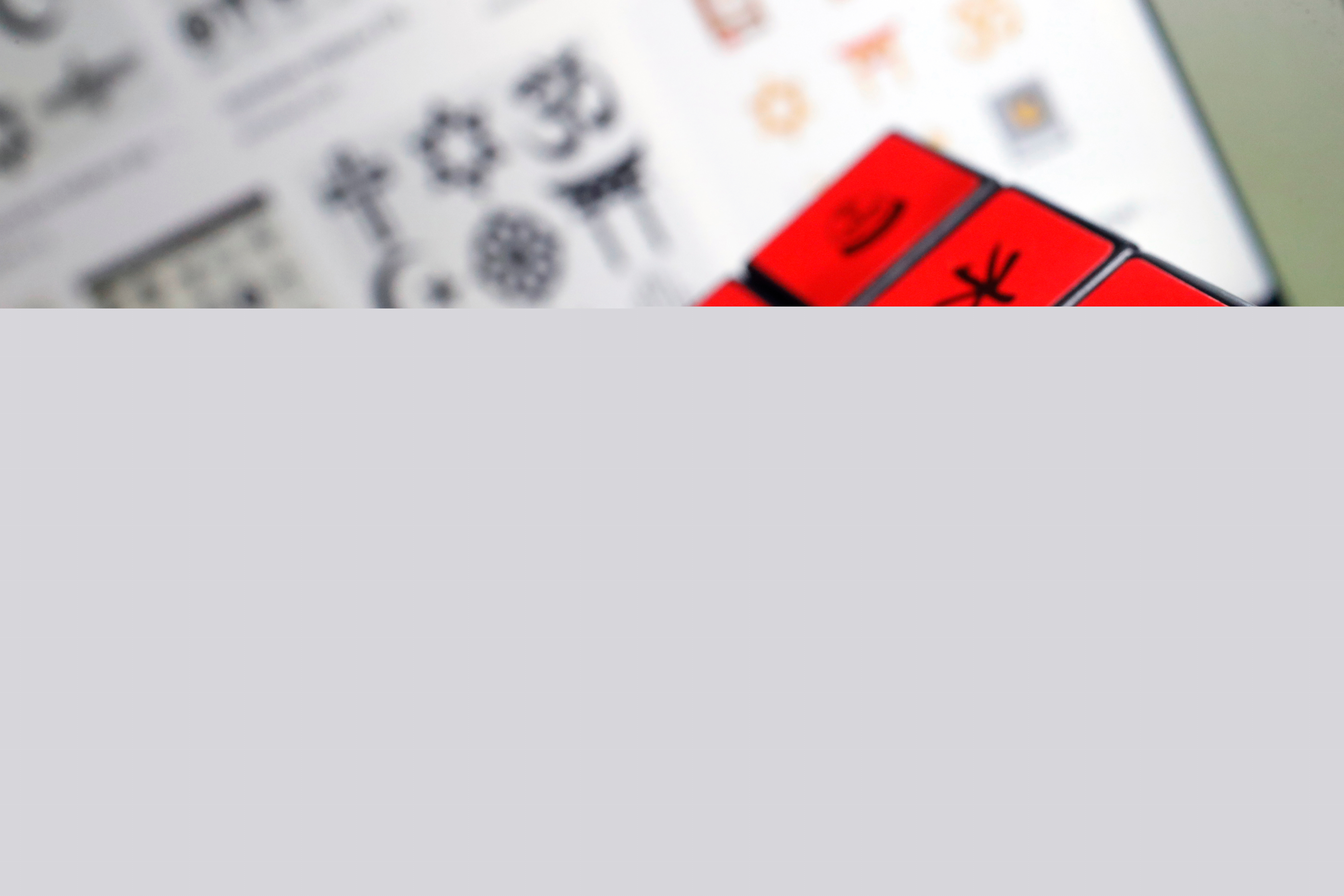 Närbild på en Rubiks kub med olika religiösa symboler utöver kubens färger.