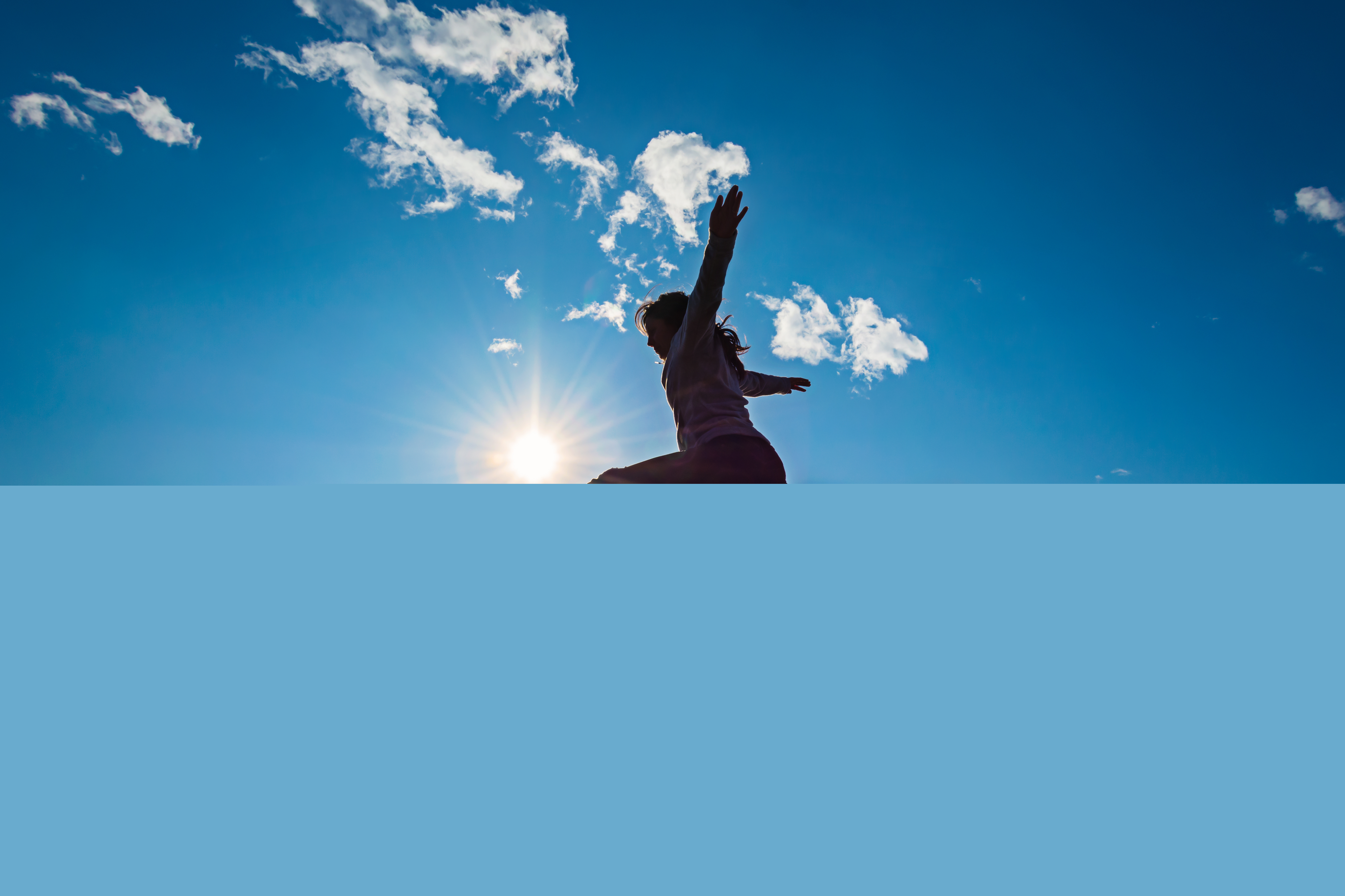 En flicka hoppar på en brygga i solen.