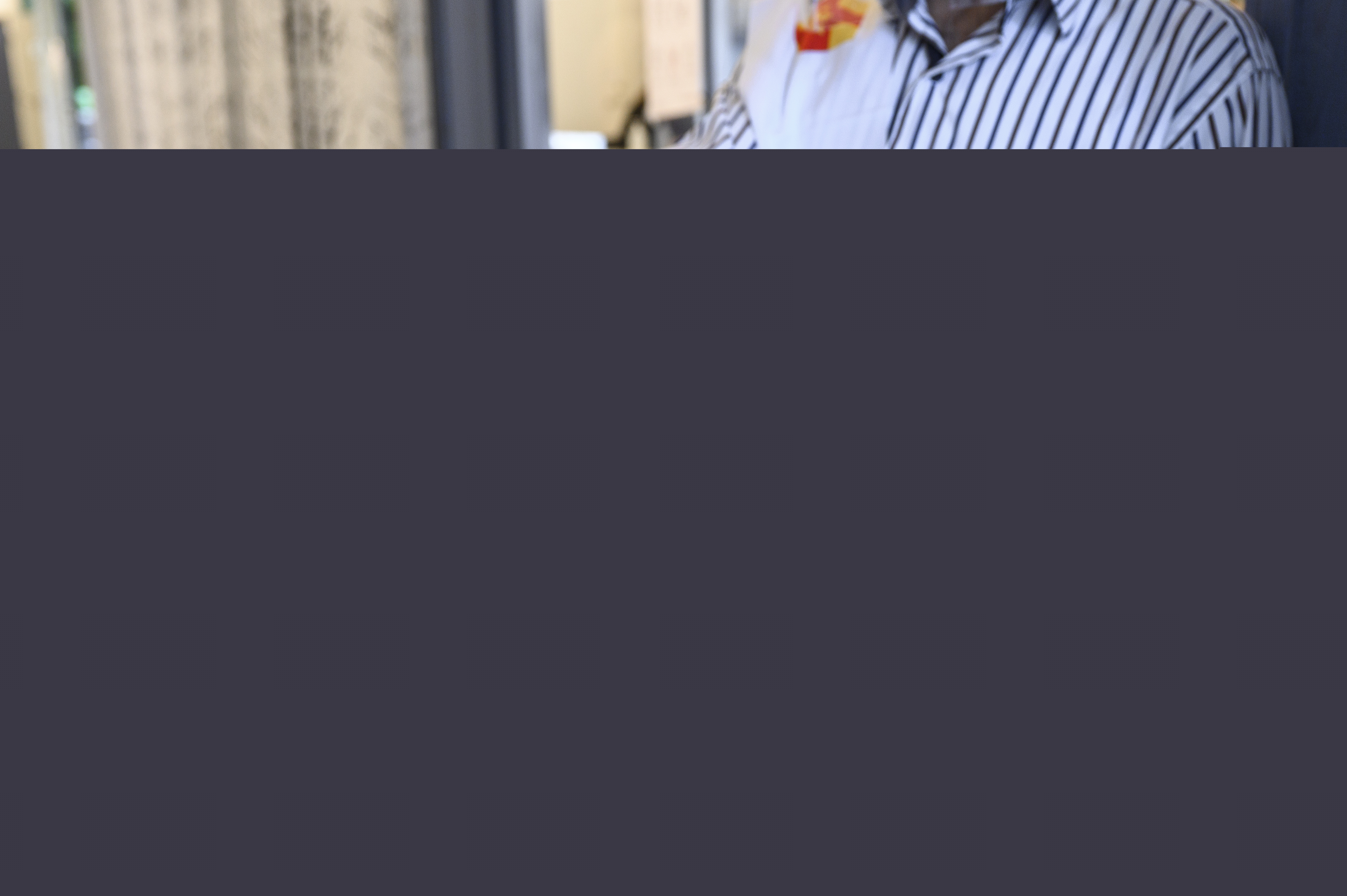 En man från Svenska kyrkan räcker över ett valkuvert till någon.