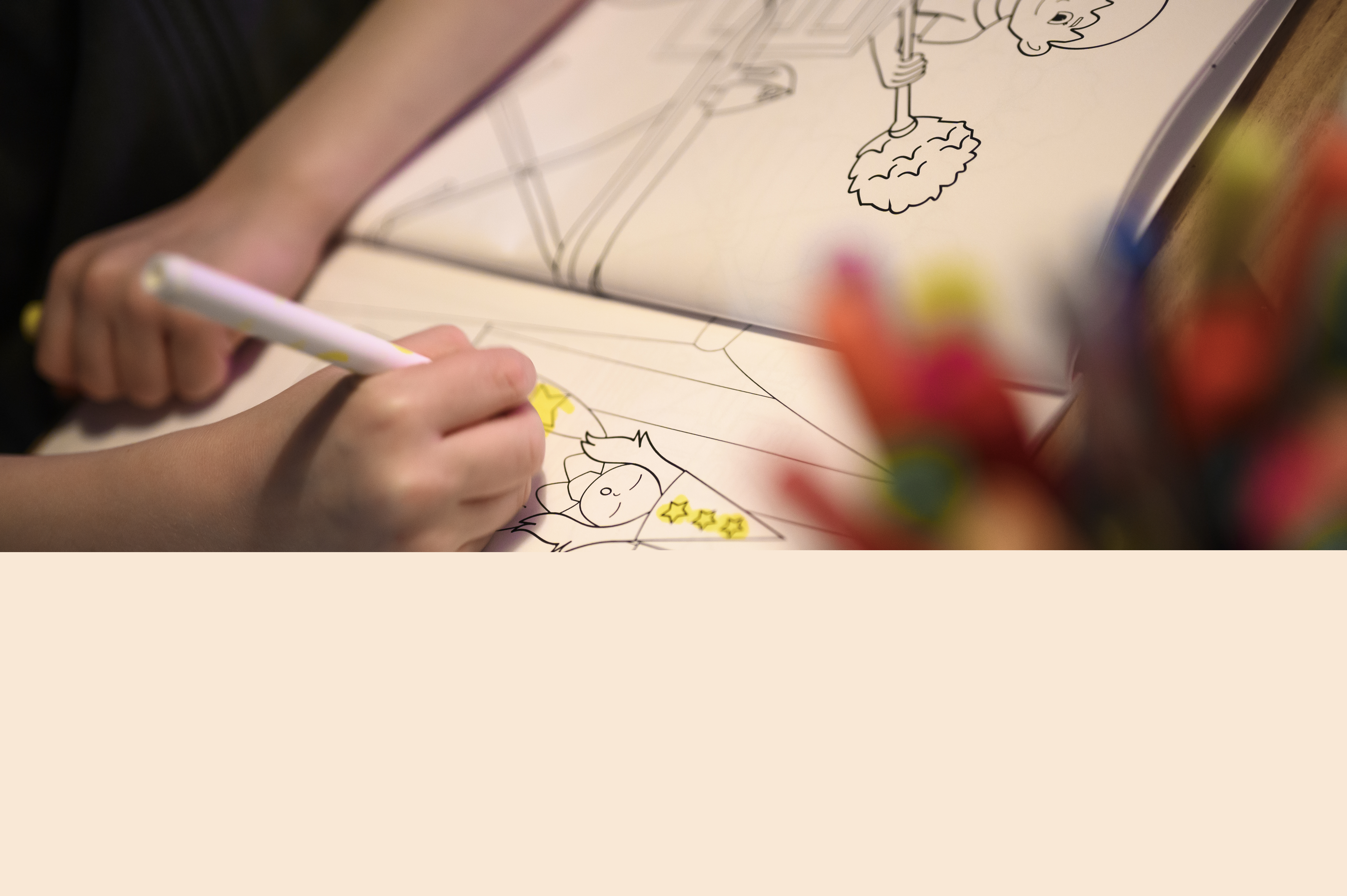 Närbild på ett barn som sitter och färglägger i en målarbok med jultema.