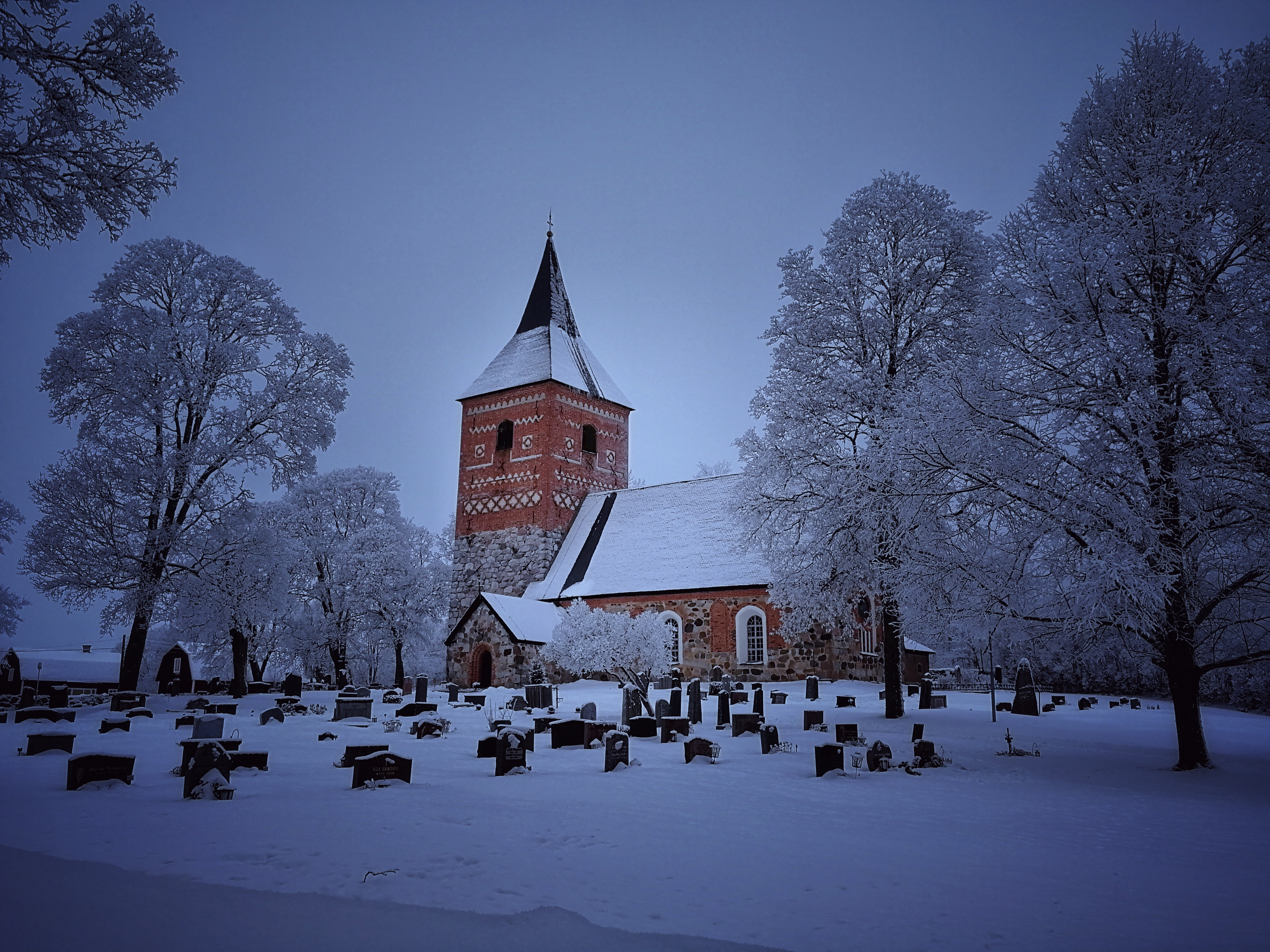 Snötäckt kyrka och kyrkogård
