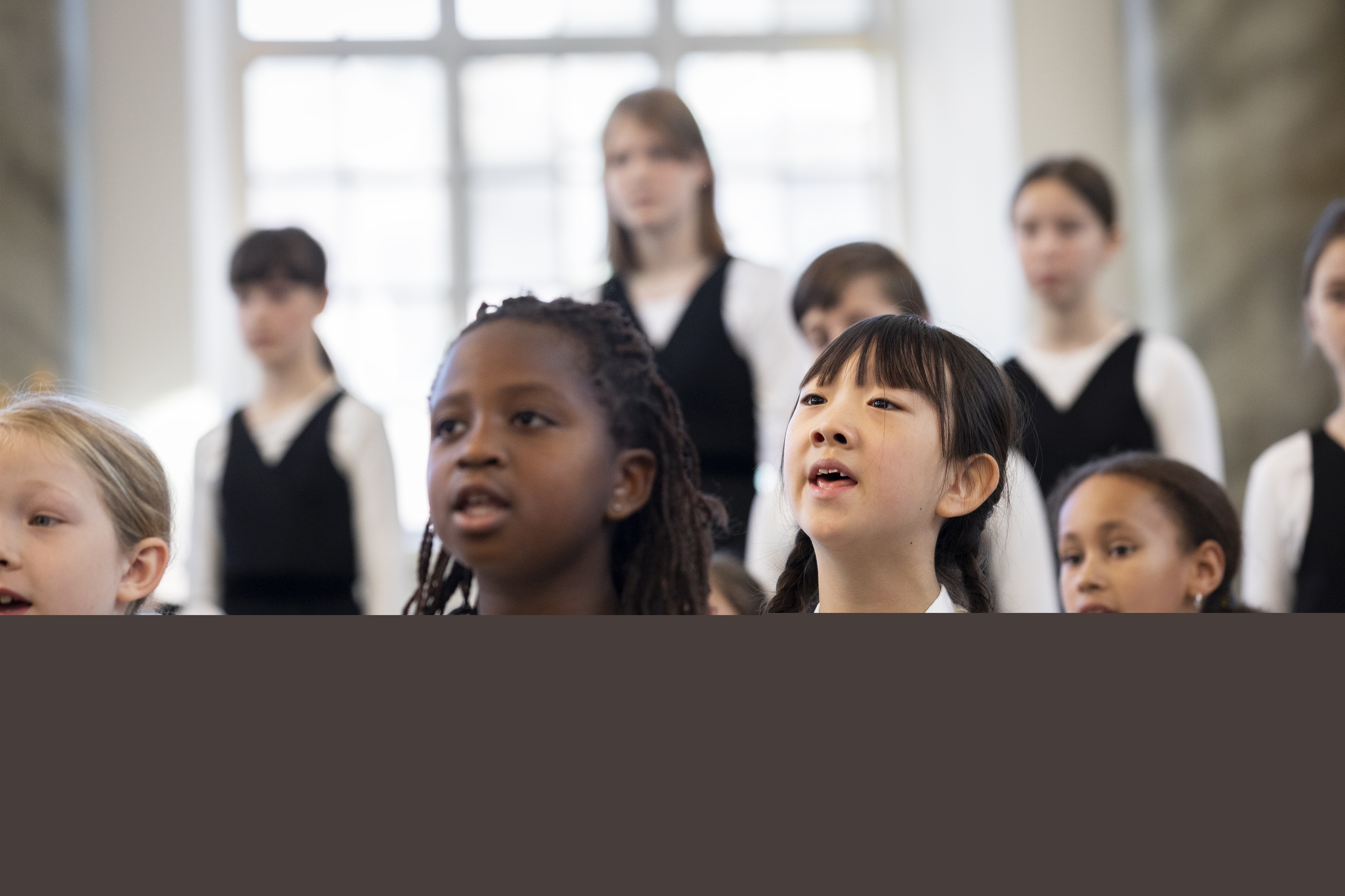 Medlemmar i en barnkör står och sjunger i en kyrka.