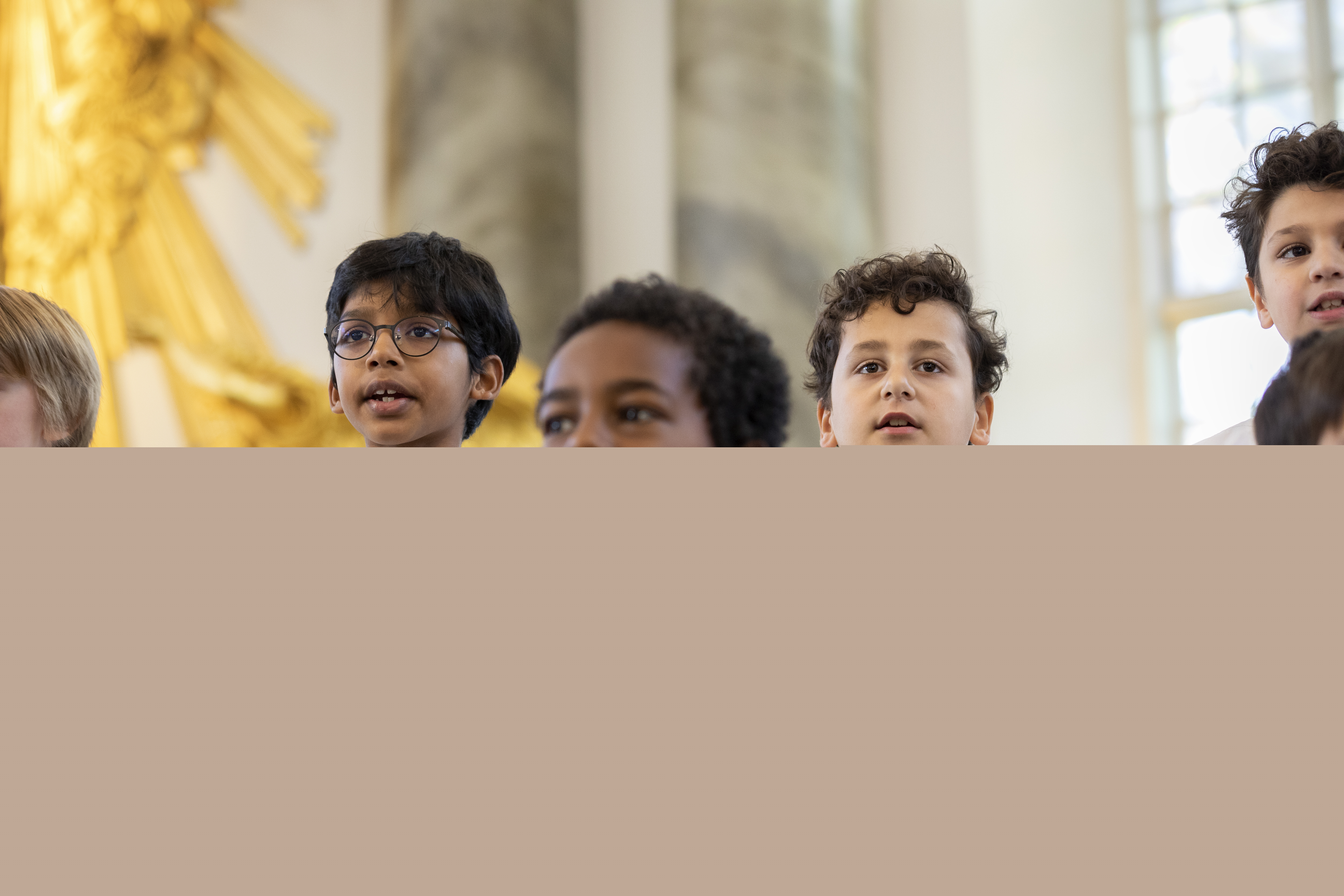 Medlemmar i en barnkör står och sjunger i en kyrka.