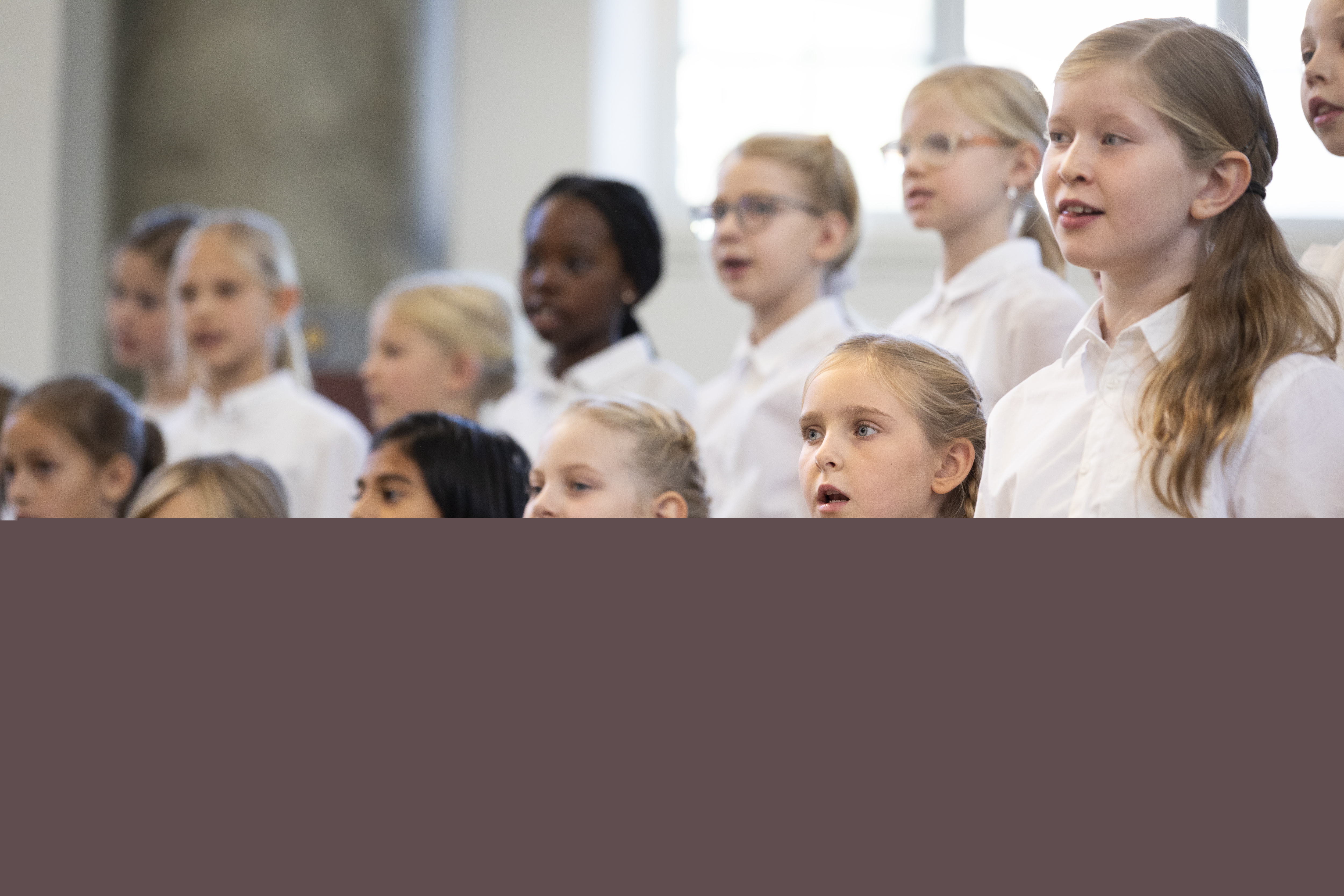 Medlemmar i en barnkör står och sjunger i en kyrka.