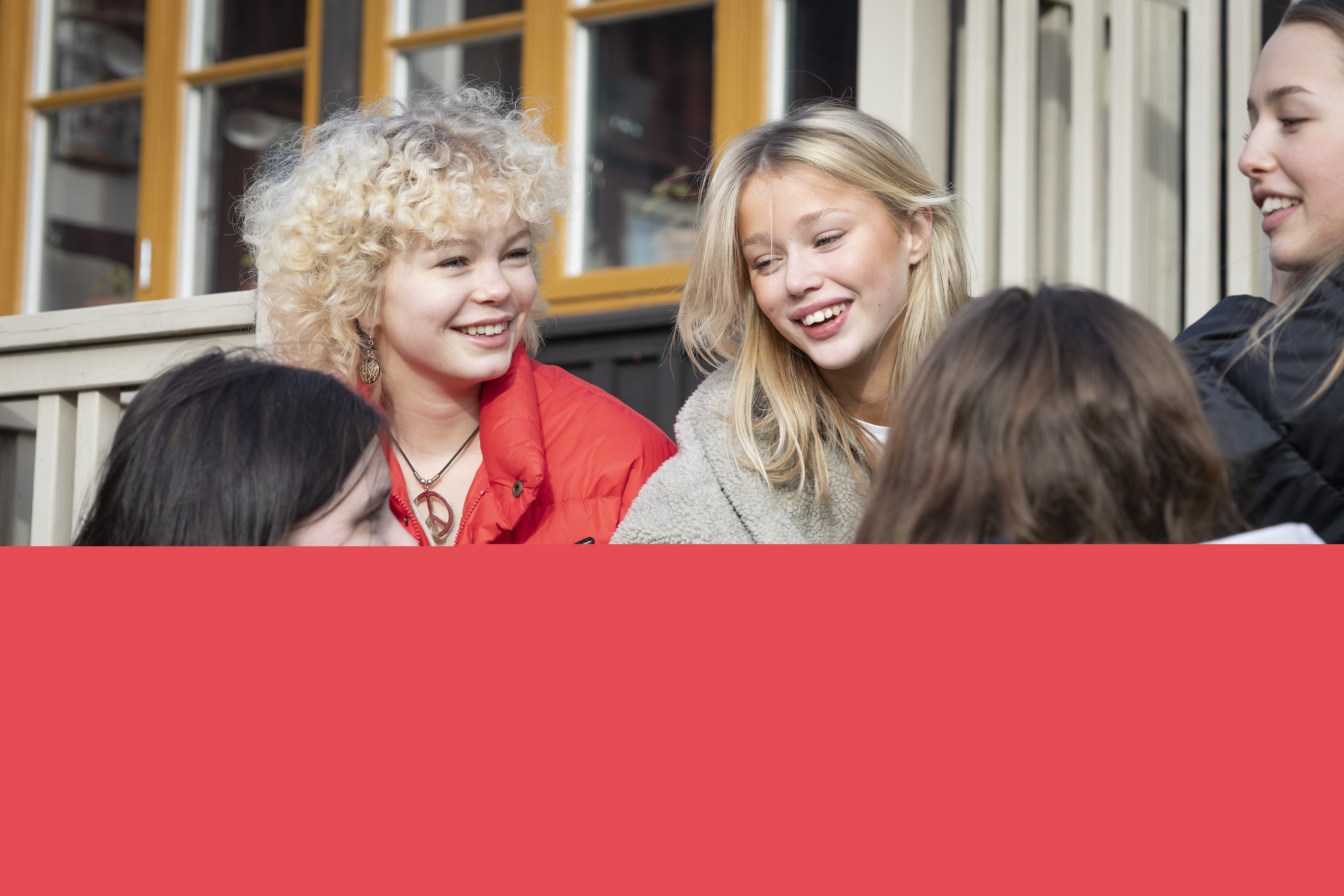 Några tonårstjejer sitter på en hustrappa.