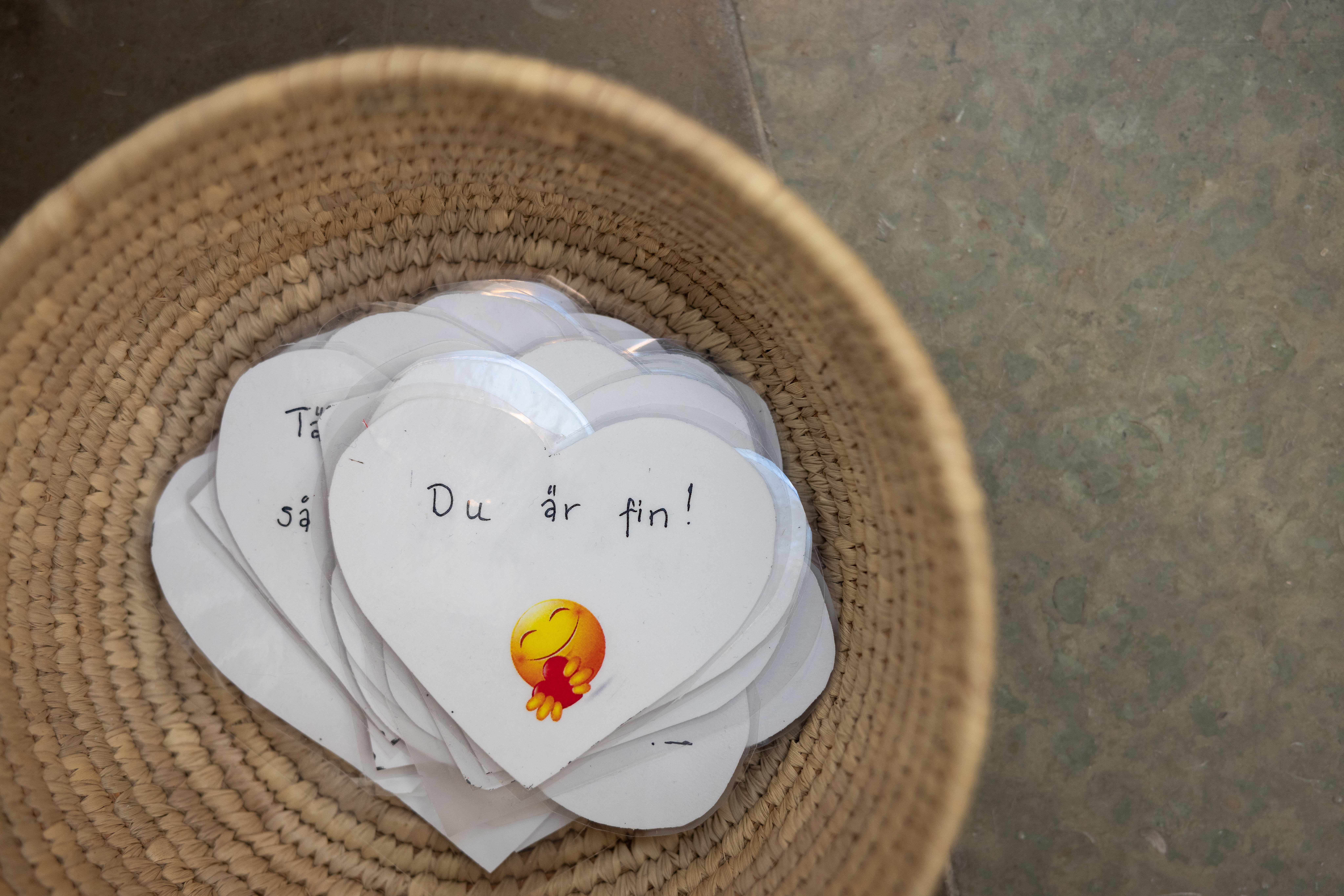 I en korg ligger utklippta pappershjärtan. På det översta står det Du är fin! och en smiley med hjärta.
