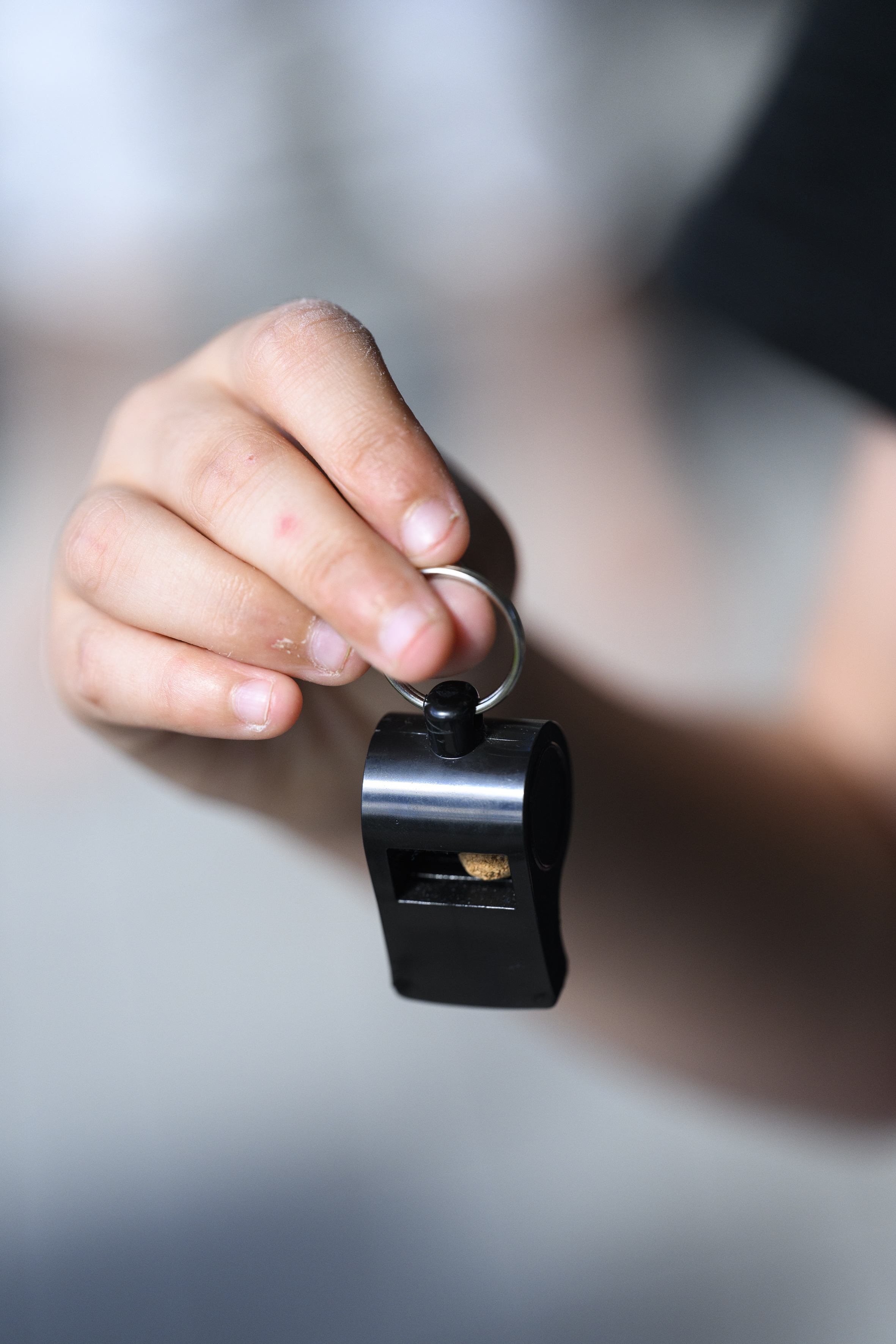 Närbild på en barnhand som håller i en visselpipa.