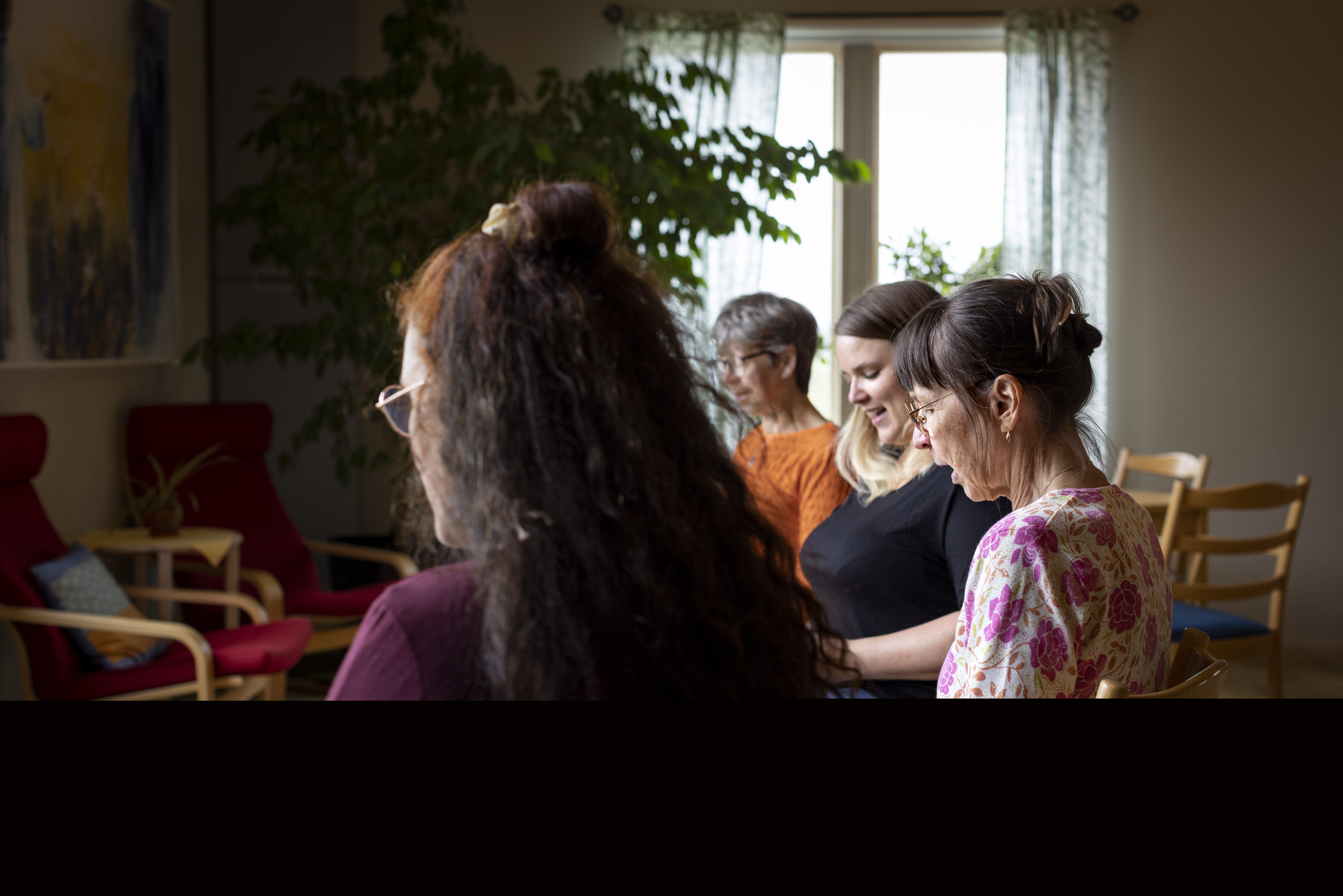 Några kvinnor sitter och sjunger tillsammans.