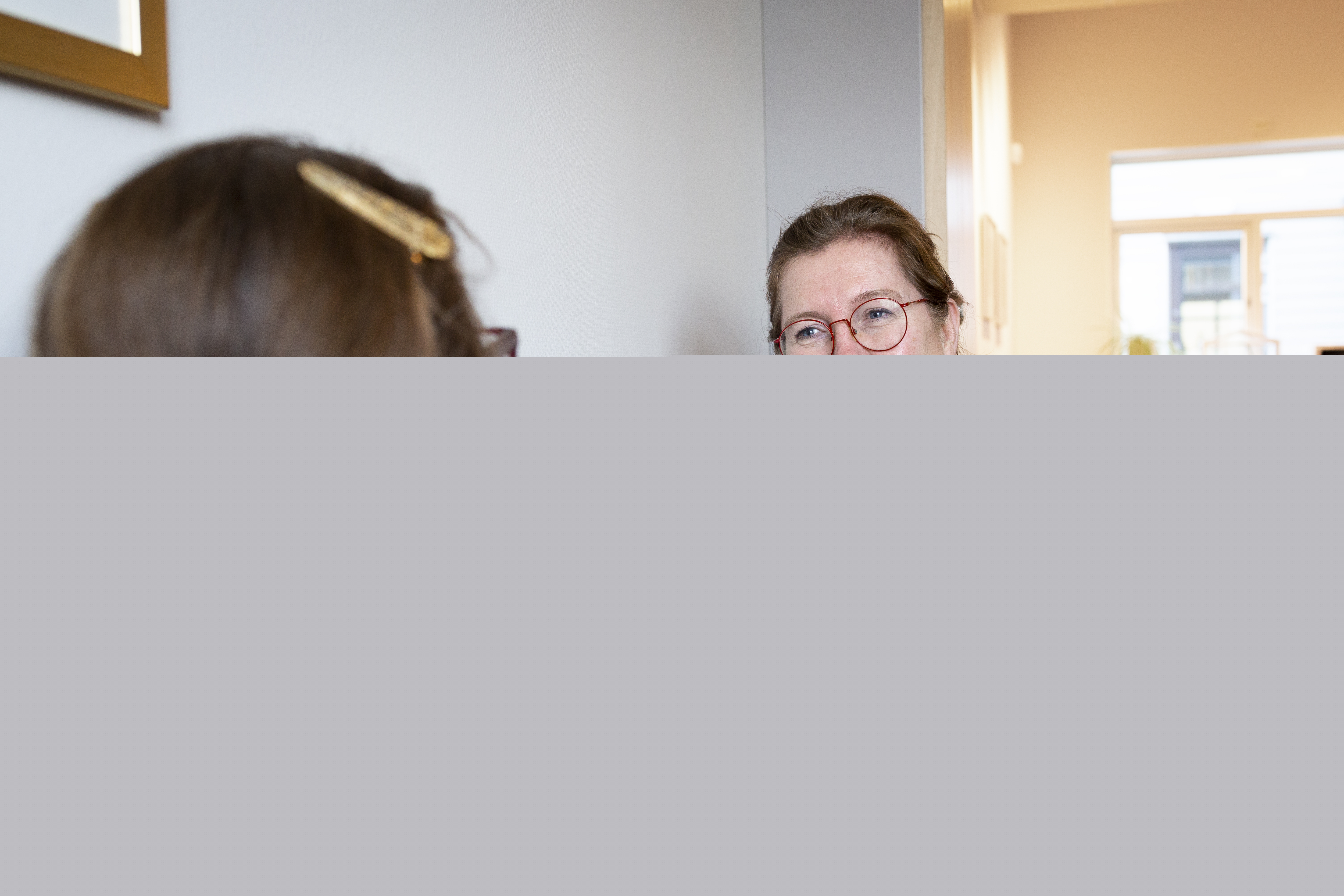 En kvinnlig diakon sitter och samtalar med en en ung tjej.