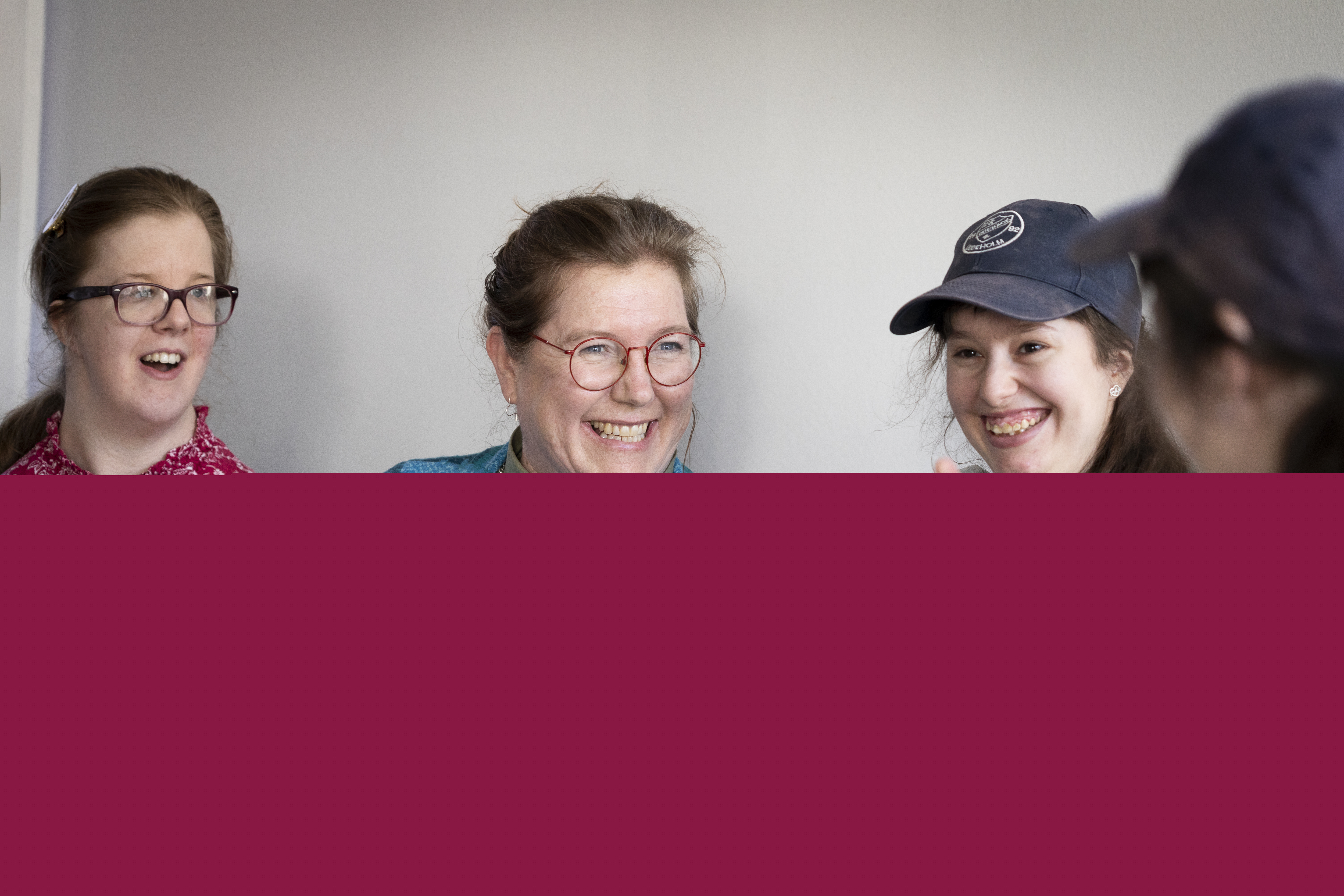 En kvinnlig diakon sitter och pratar med ett gäng ungdomar.