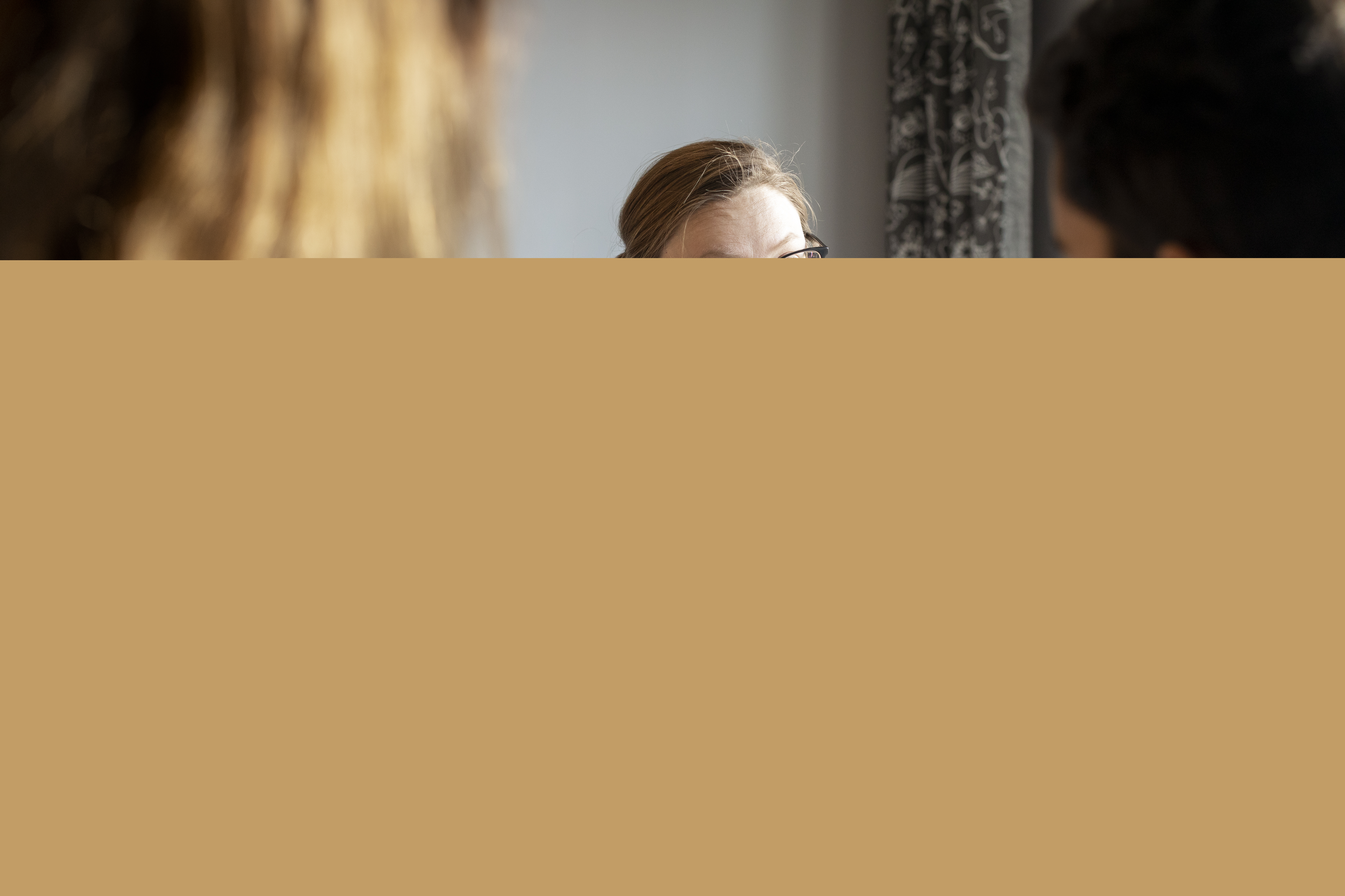 En kvinnlig diakon sitter och samtalar med en man och en kvinna.