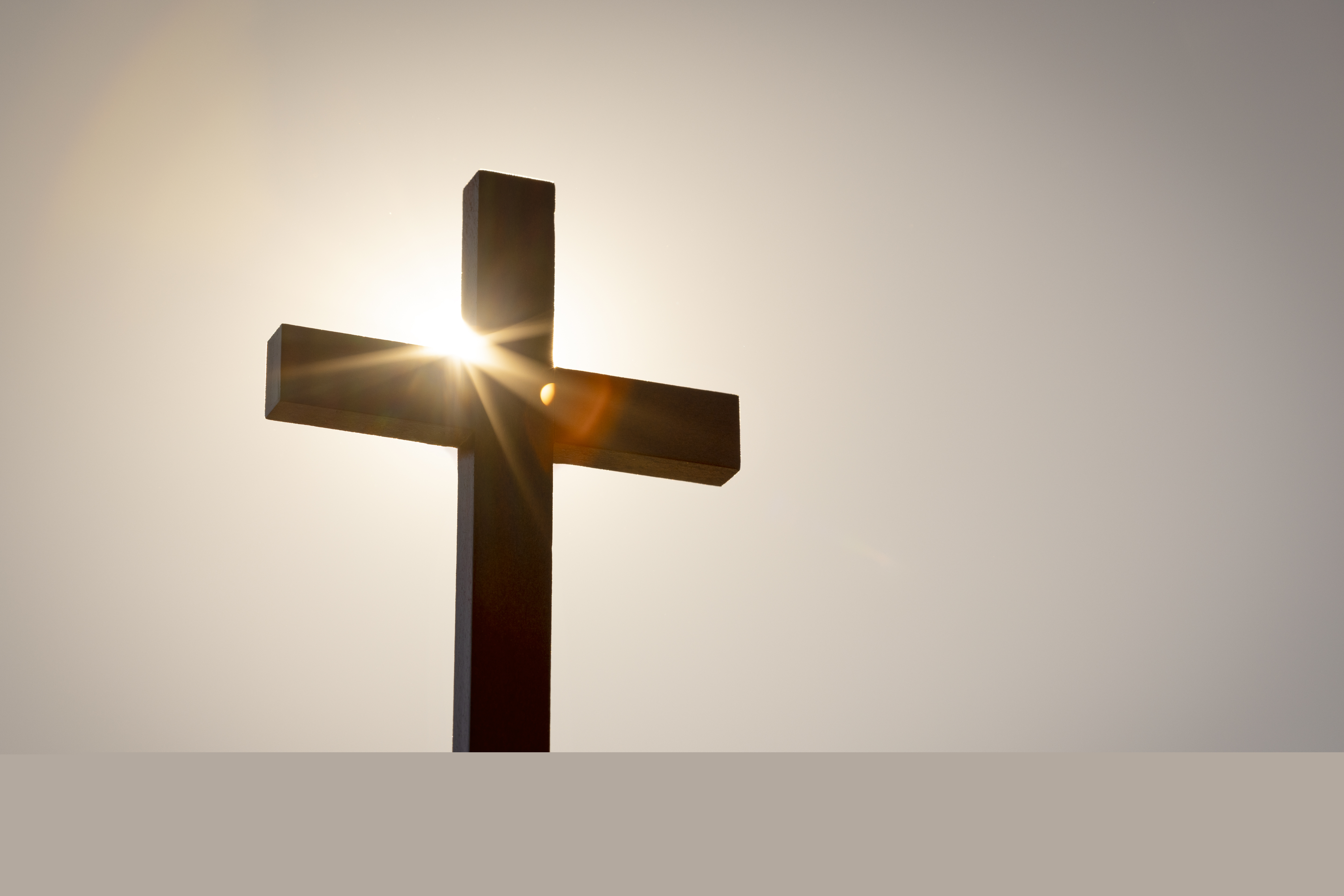 Ett enkelt kors i motljus.