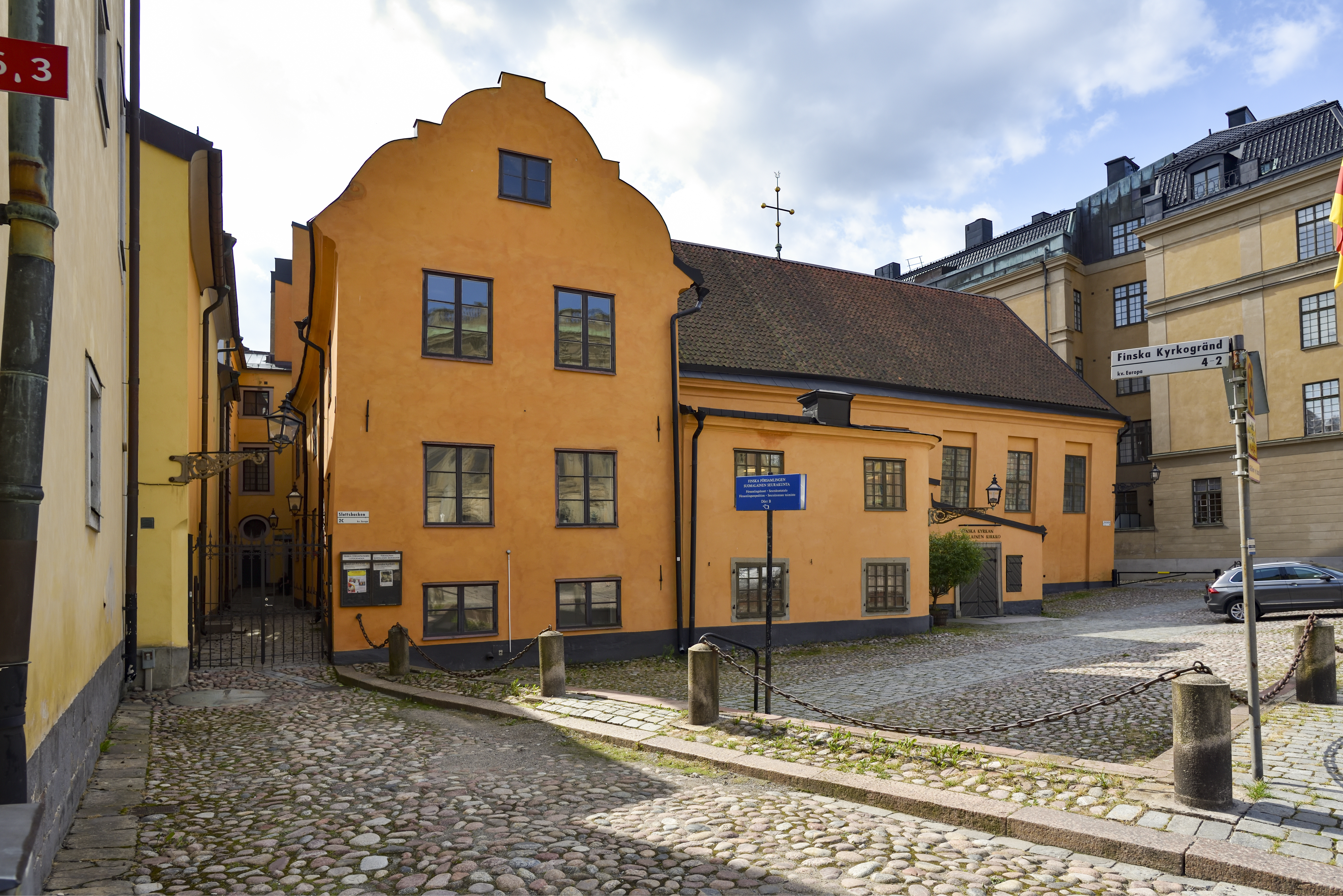 Ett honungsfärgat stenhus vid en kullerstensbelagd gata.