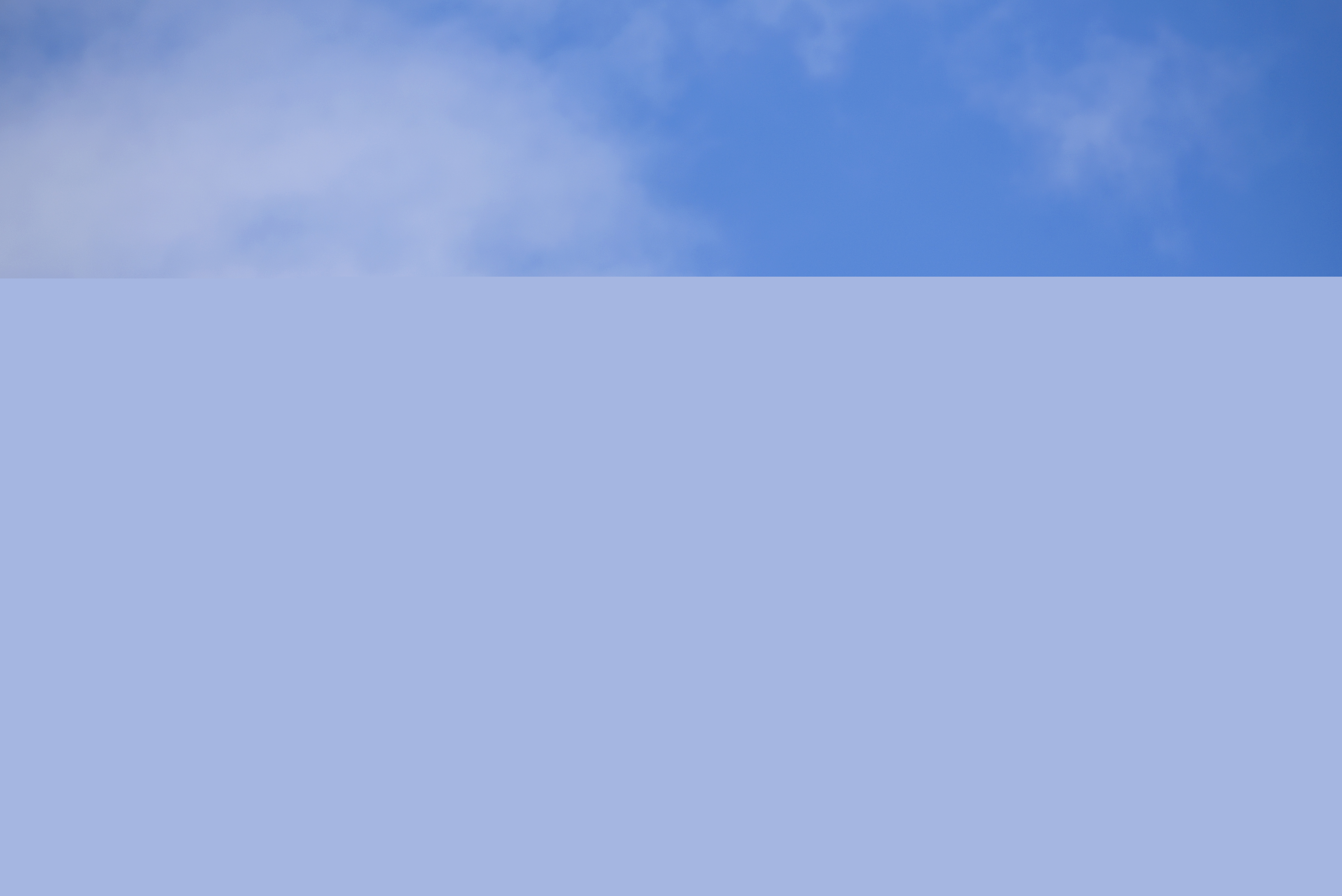 En kyrktupp mot blå himmel.