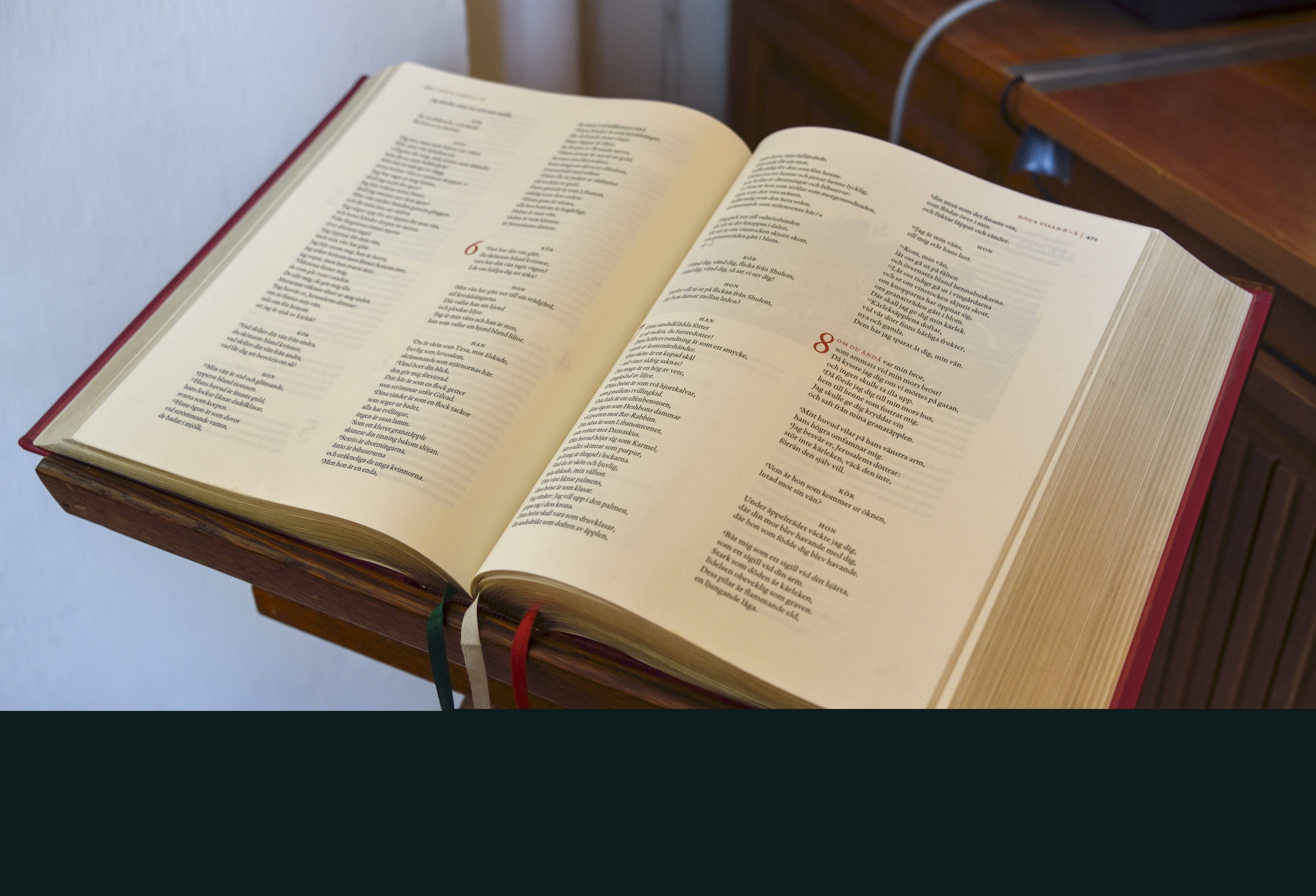 En bibel ligger uppslagen på ett bokställ.