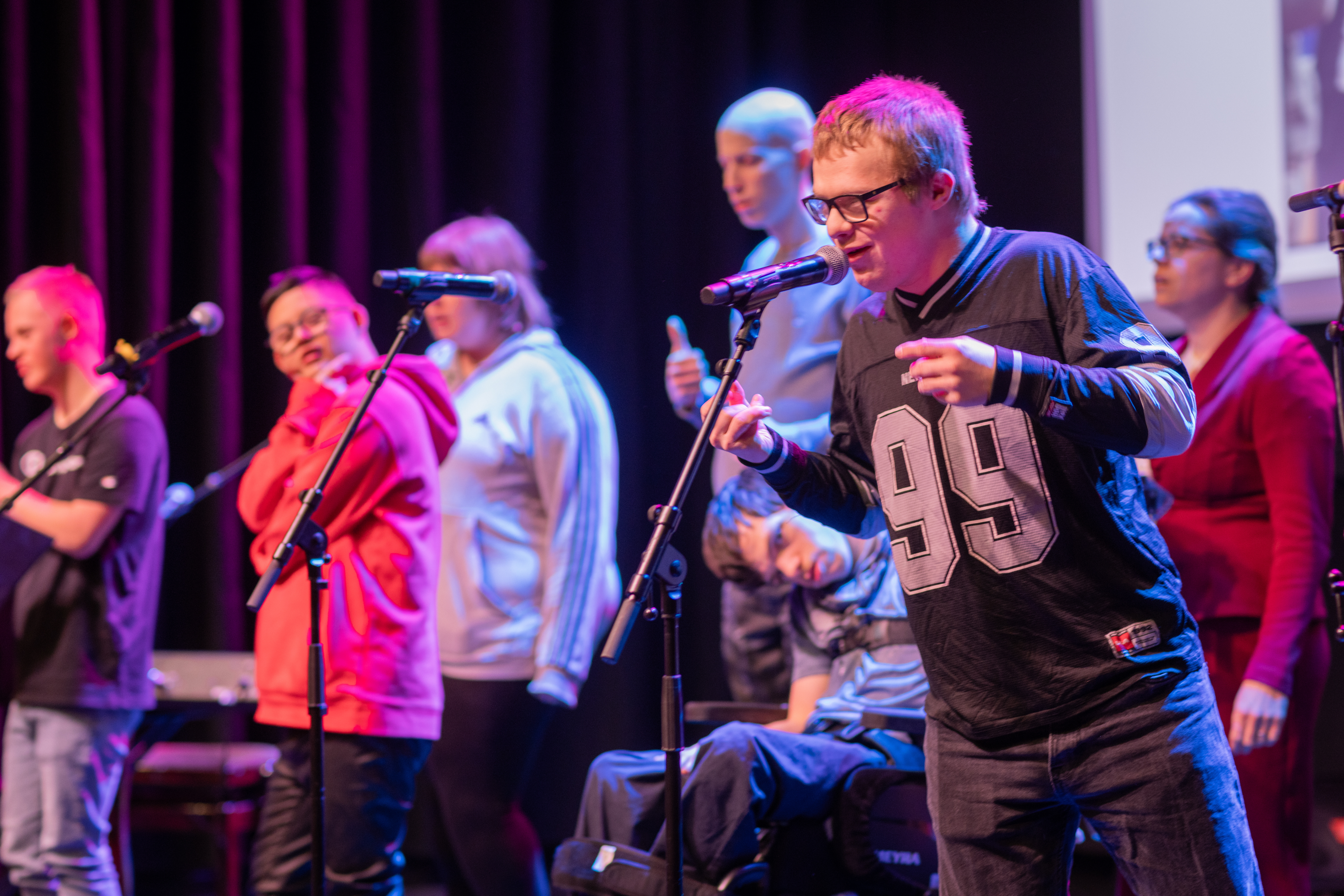 Några ungdomar med olika funktionsvariationer framför musik på en scen.