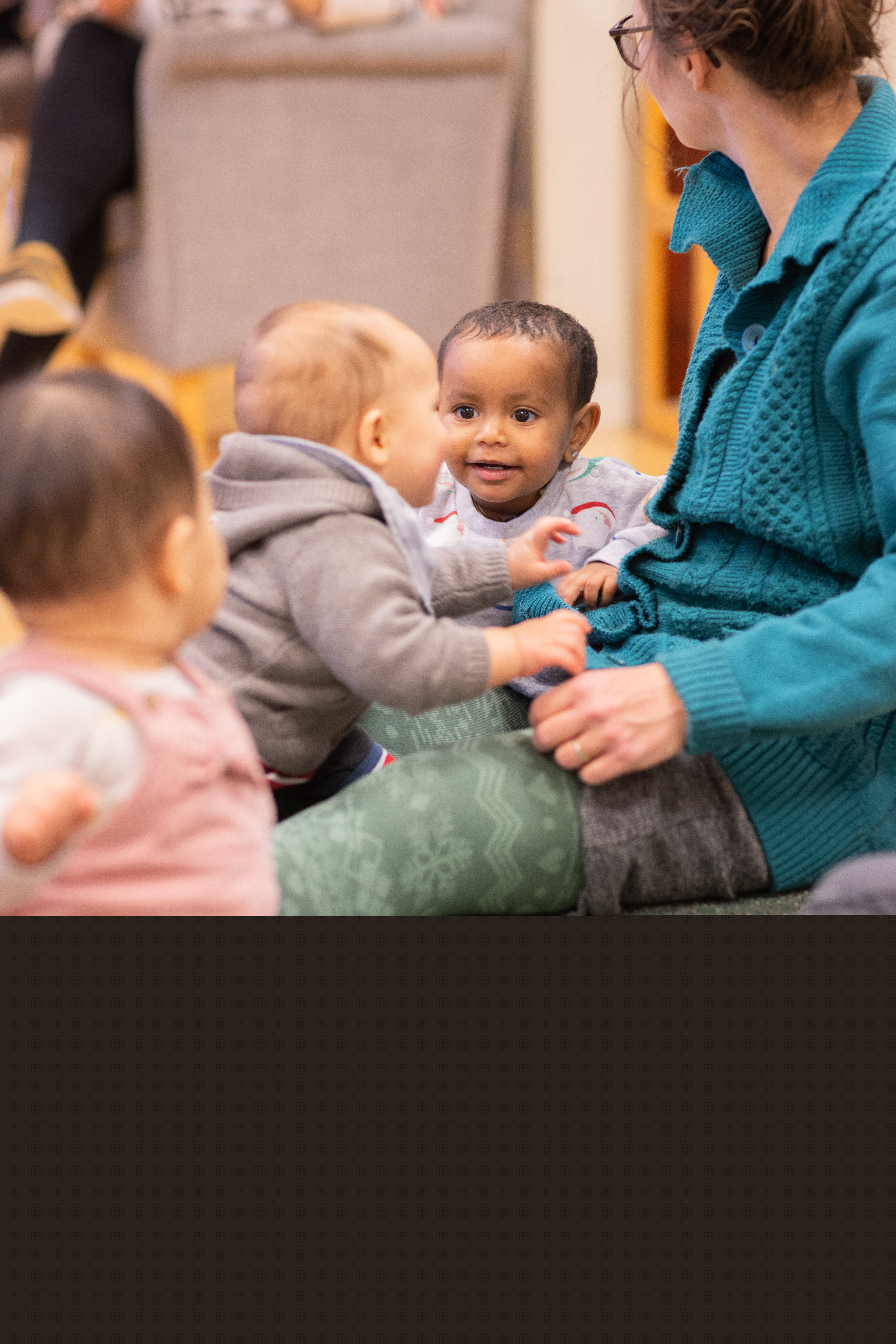 Några bebisar sitter på golvet och skrattar.