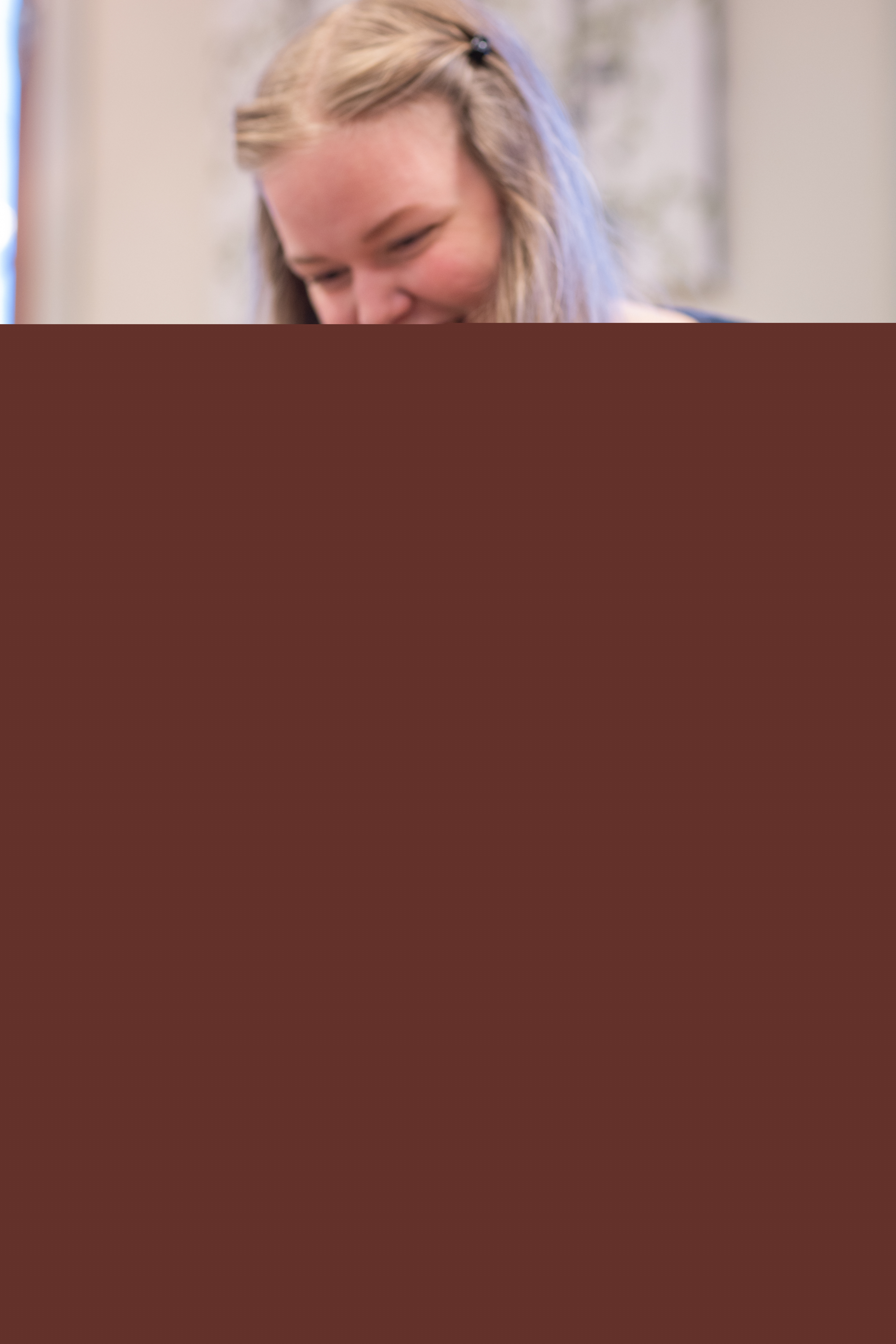 En kvinna sitter på golvet och leker med sin bebis.