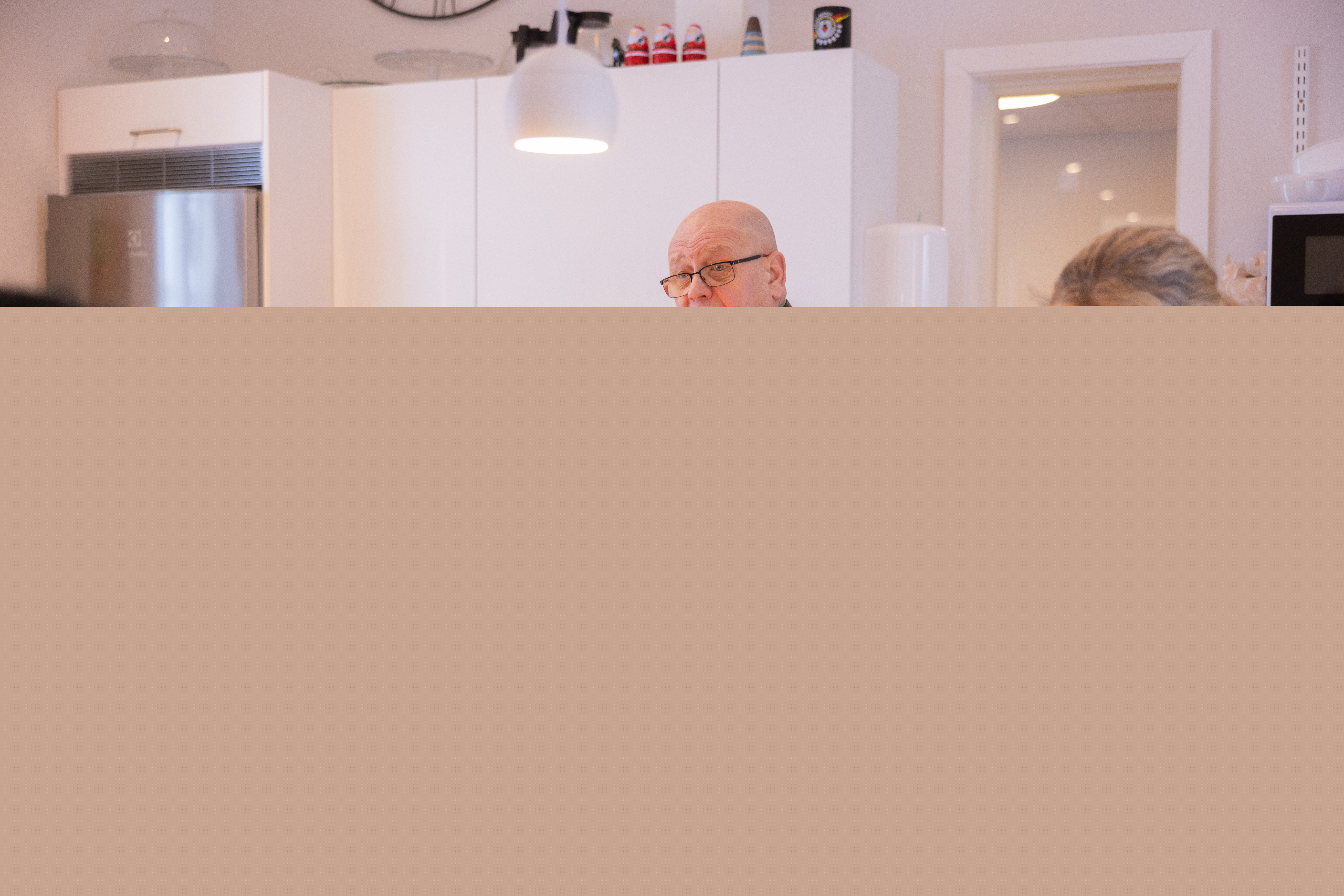 Två kvinnor, en manlig diakon och en kvinnlig präst förbereder fika i ett kök.