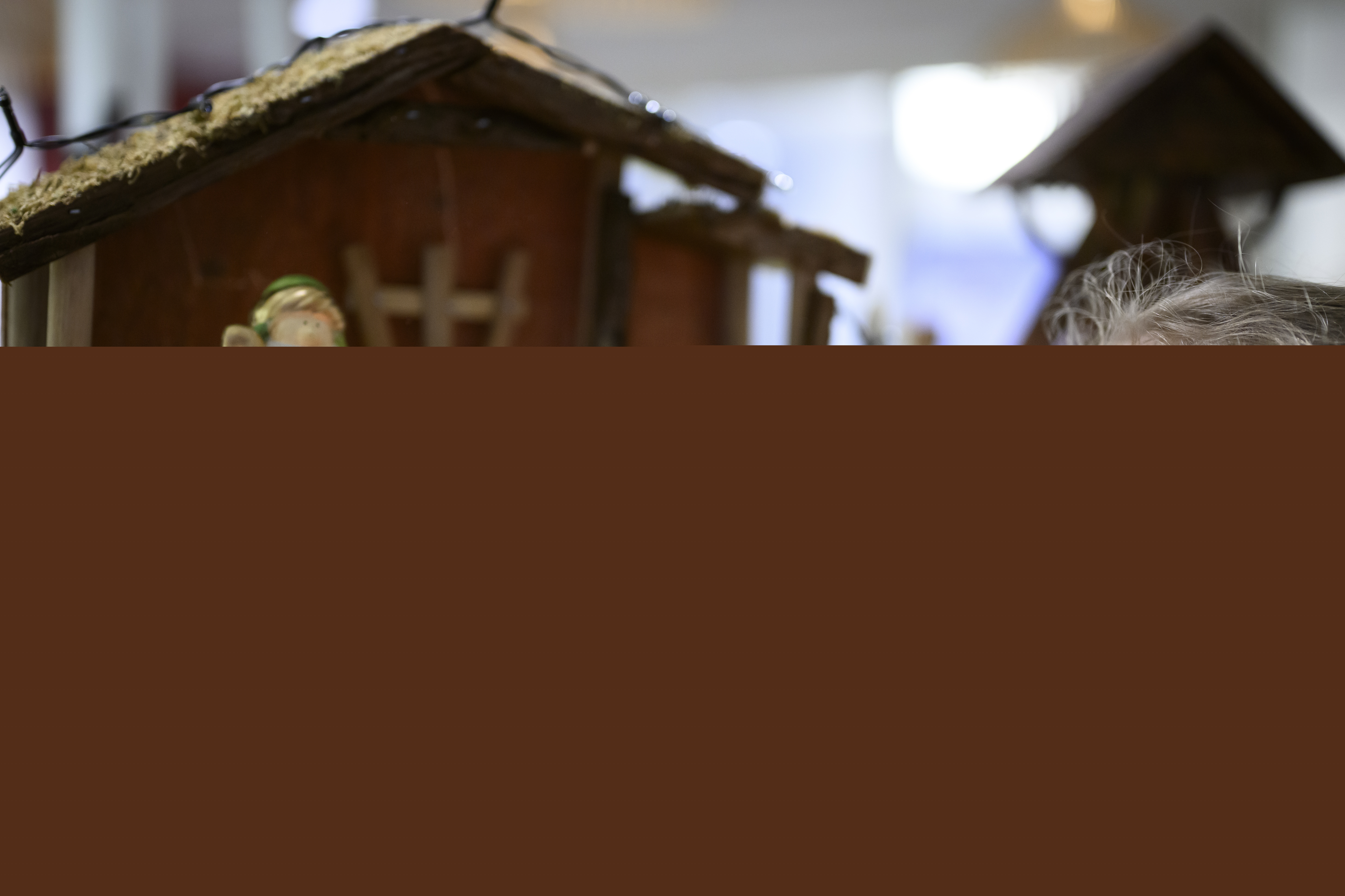 Ett litet barn leker med en julkrubba.