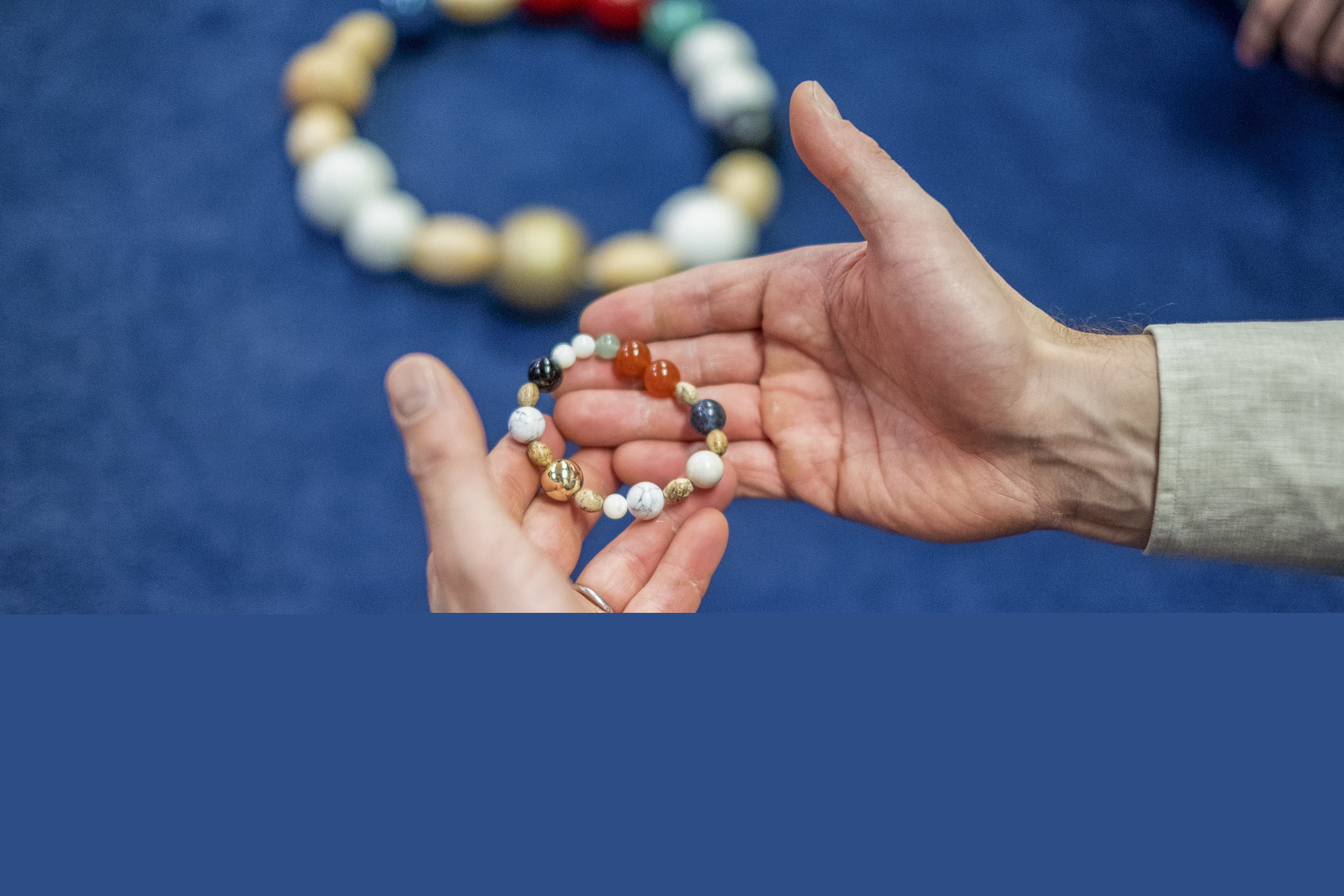 Två kupade händer håller en frälsarkrans.