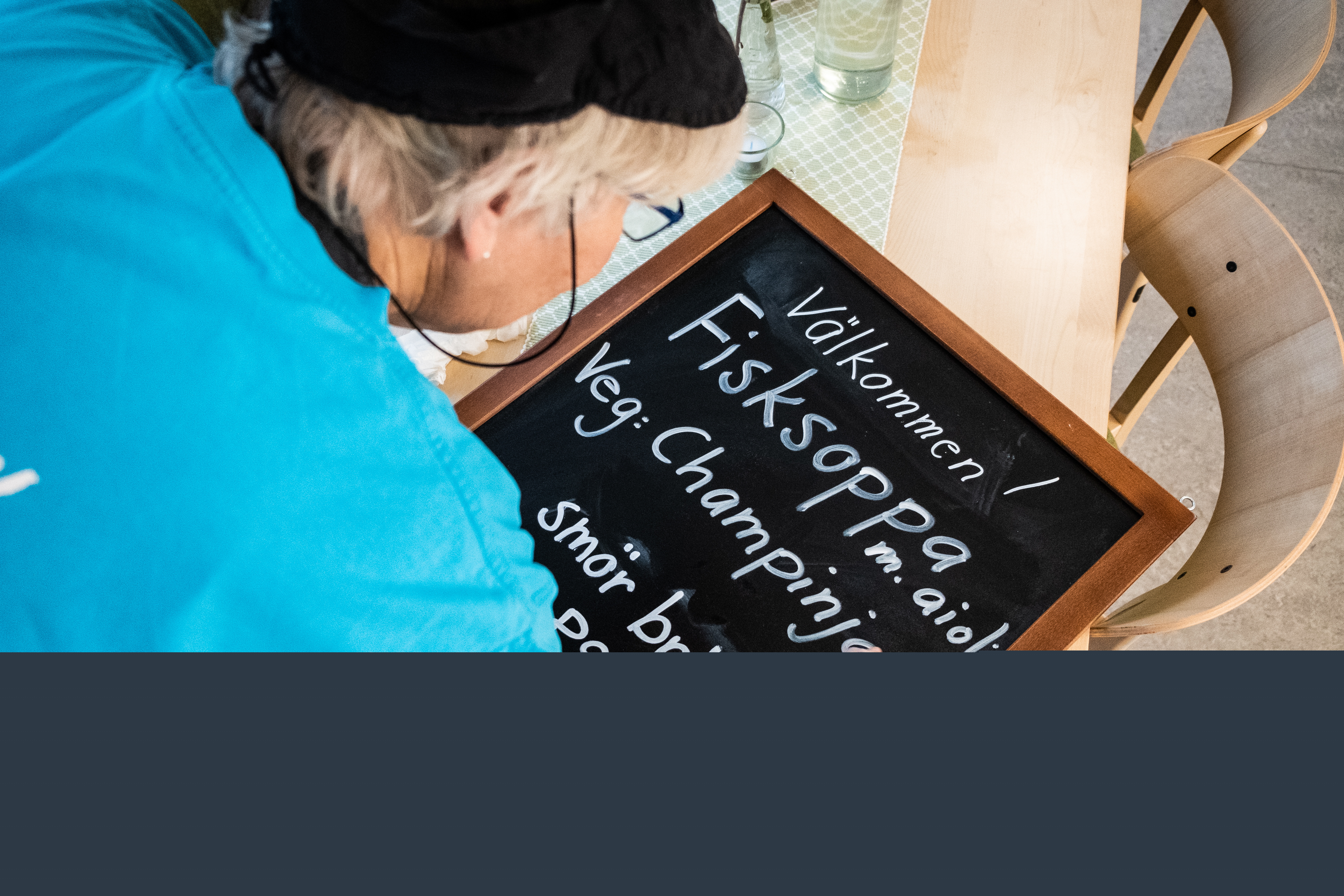 En person skriver en meny på en griffeltavla.