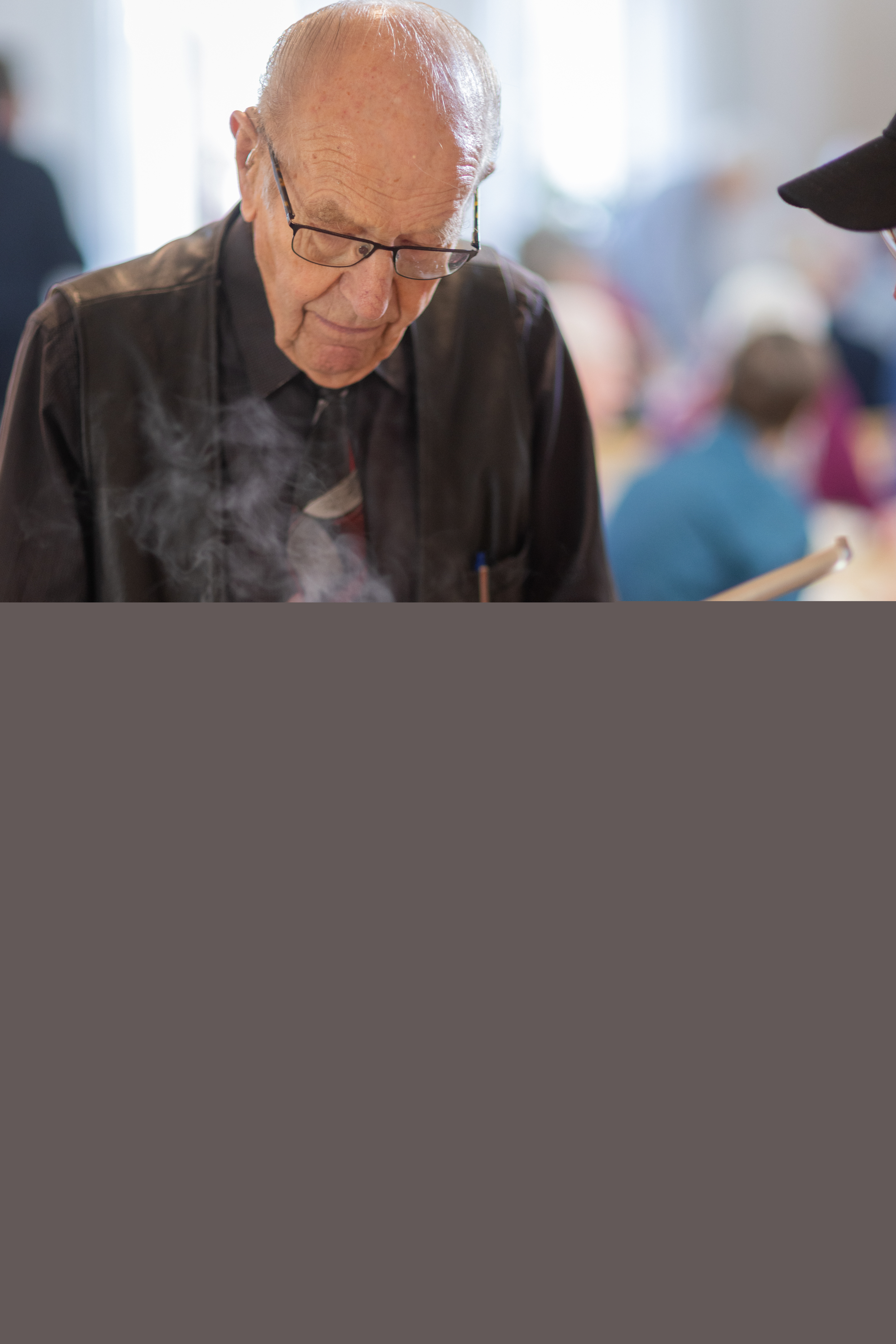 En äldre man får mat i sin tallrik i en matbespisning.