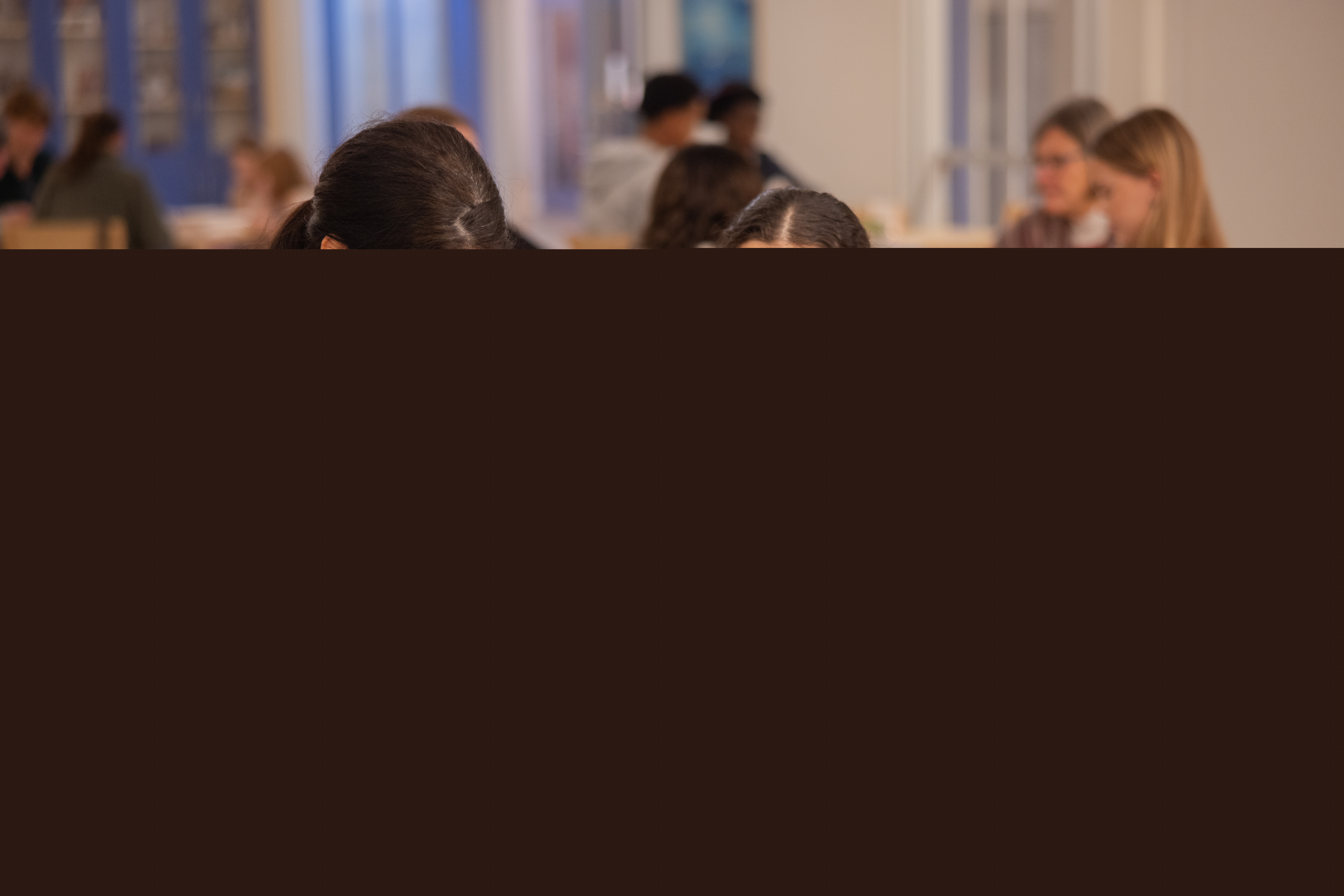 En tjej leker tittut med en liten pojke som sitter på ett bord.